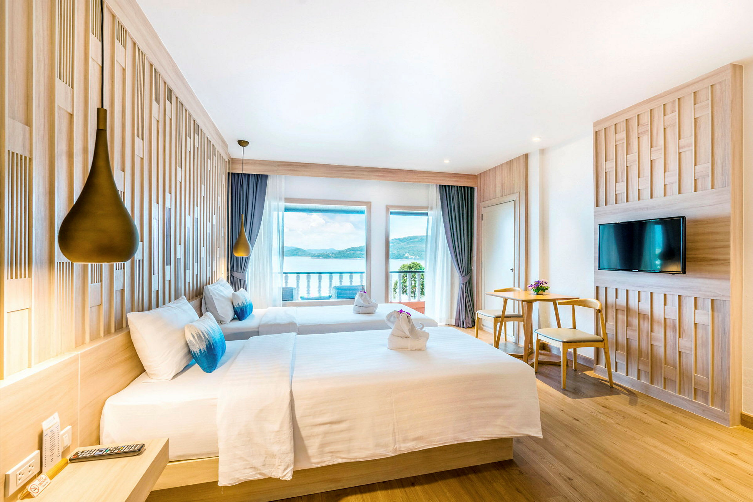 Hotellihuone kahdella vuoteella, merinäköala ja nykyaikainen sisustus. (Tekoälyn luoma teksti)
