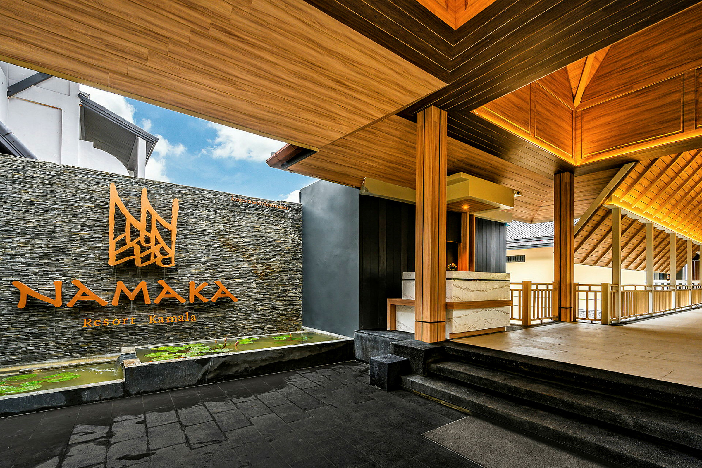 Namaka Resort Kamalan sisäänkäynti puuelementeillä ja kiviseinällä. (Tekoälyn luoma teksti)