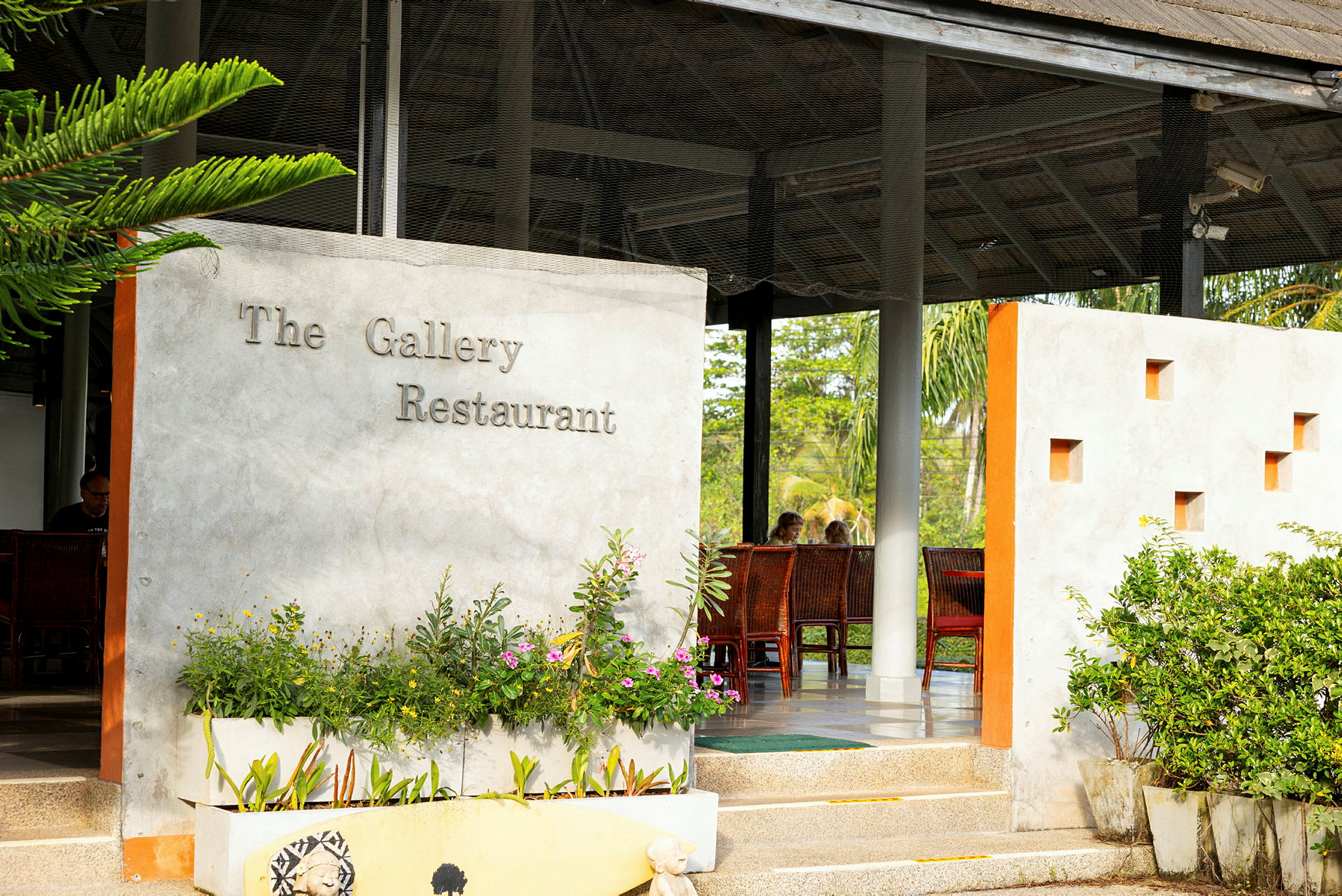The Gallery Restaurantin sisäänkäynti, jossa kasveja ja ulkokalusteita. (Tekoälyn luoma teksti)