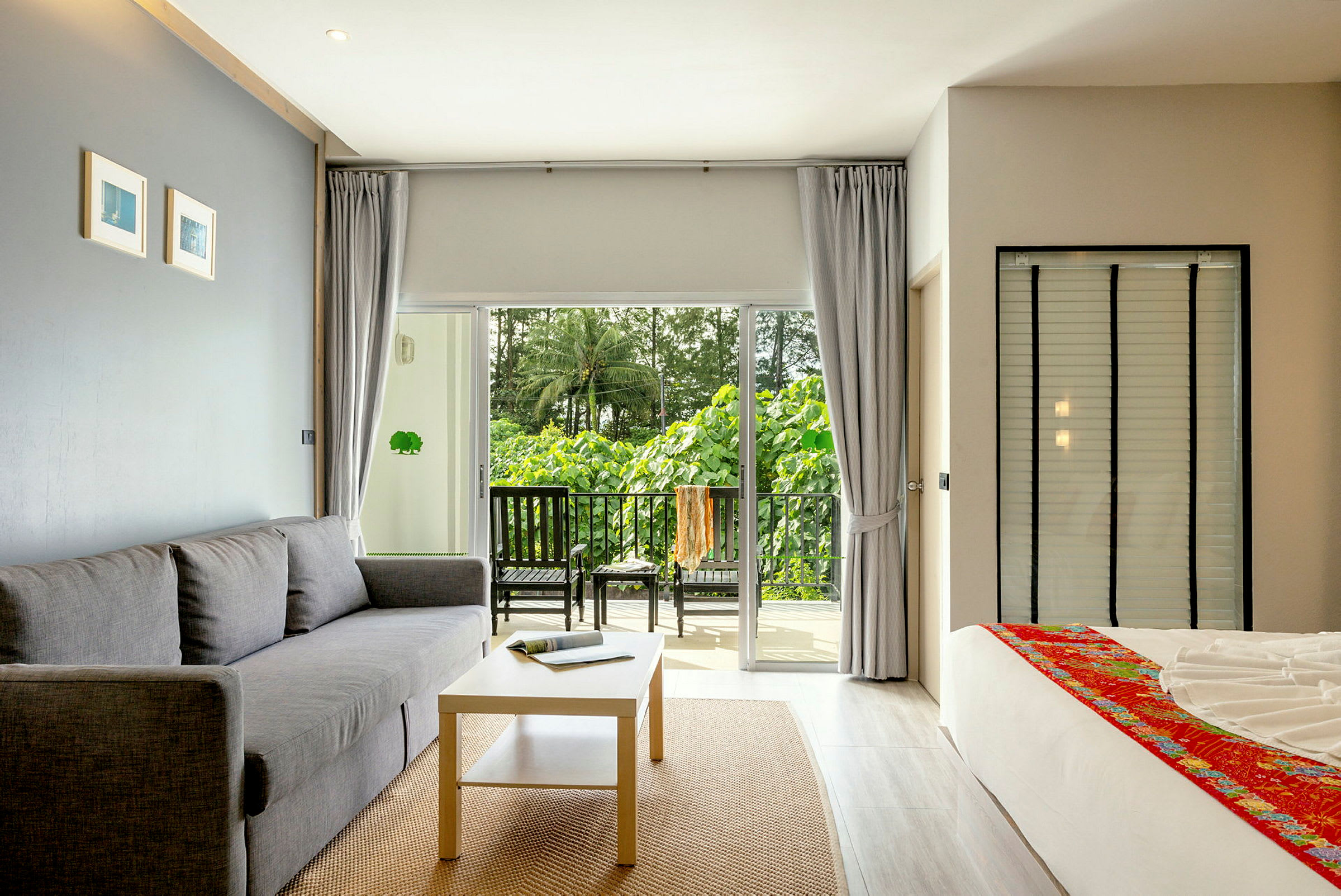 Modernisti sisustettu hotellihuone parvekkeella ja vihreä näkymä. (Tekoälyn luoma teksti)