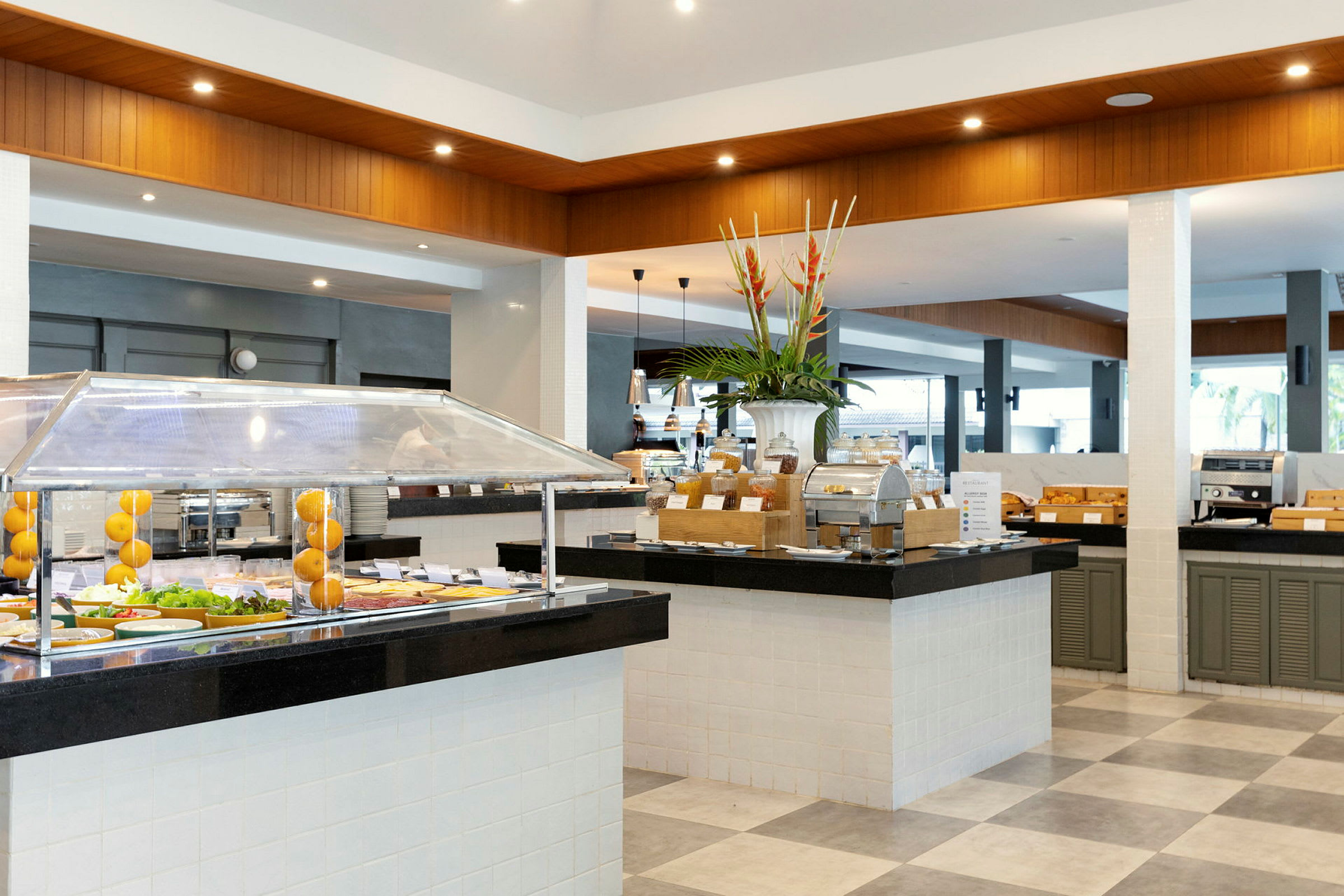 Kuva buffet-ravintolasta, jossa on eri ruokapisteitä ja koristeellinen maljakko. (Tekoälyn luoma teksti)