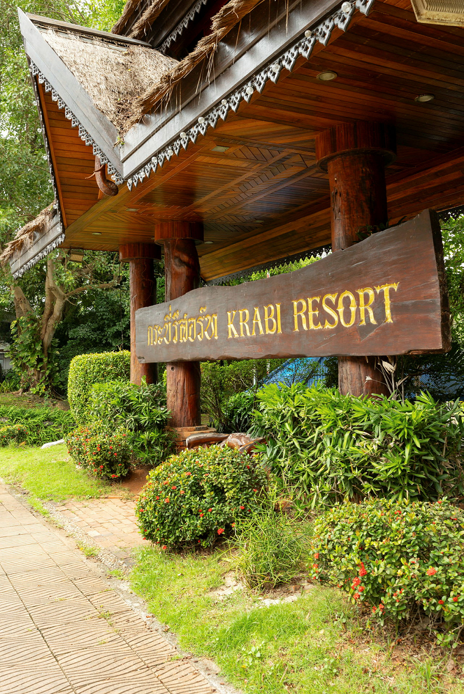 Krabi Resortin sisäänkäynnin kyltti, jonka ympärillä on vehreyttä. (Tekoälyn luoma teksti)