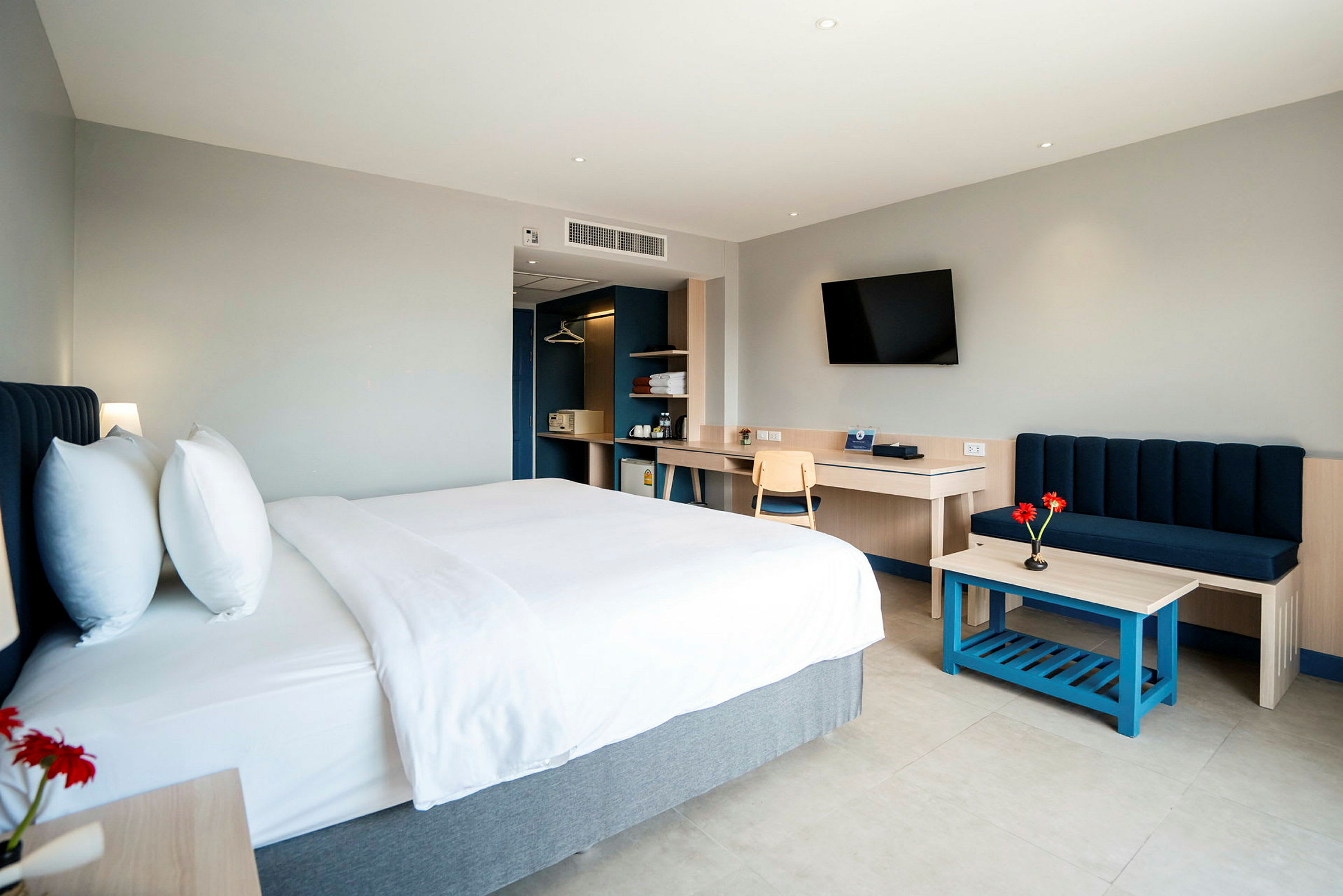 Moderni hotellihuone, jossa on parivuode, sohva ja työpöytä. (Tekoälyn luoma teksti)