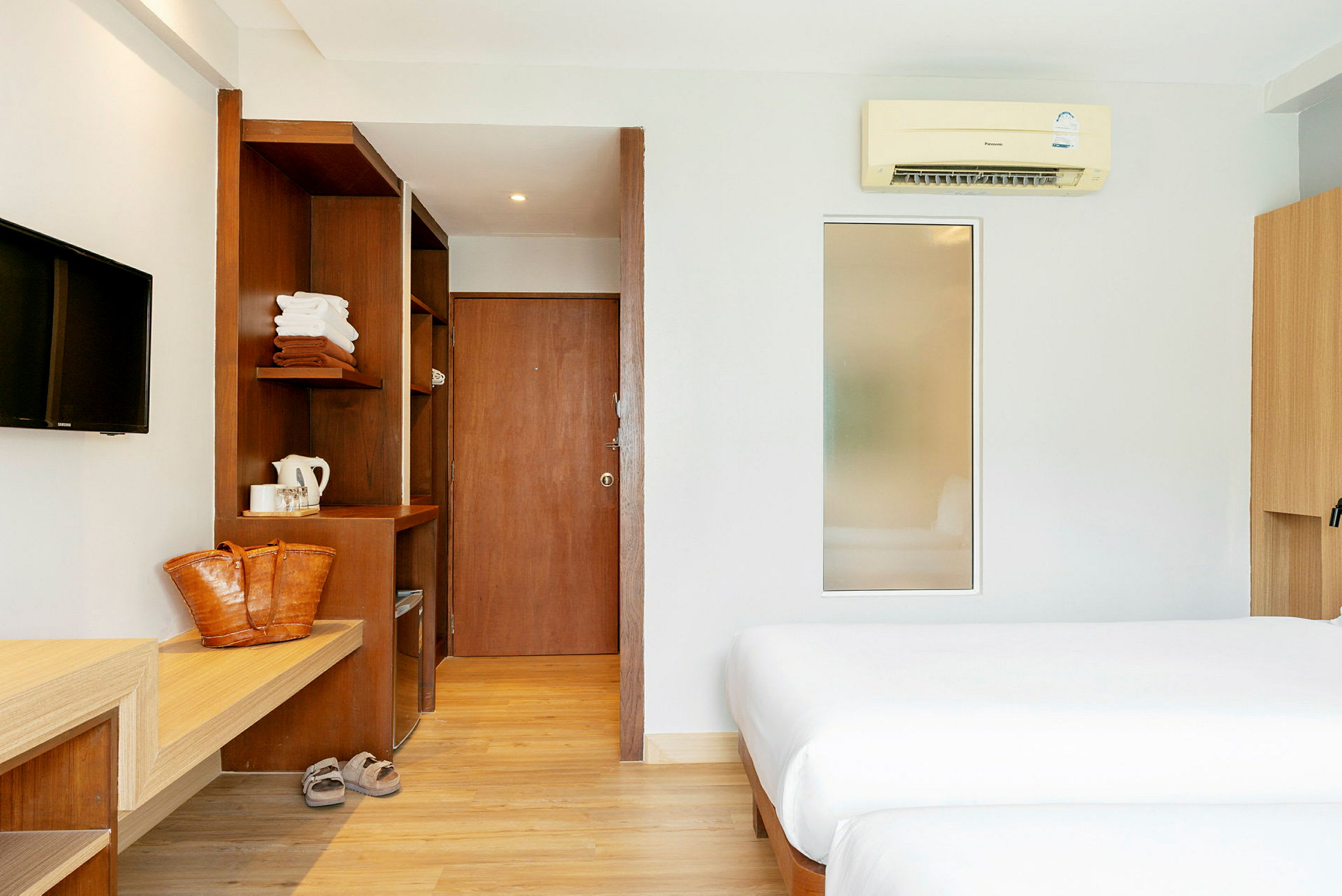 Hotellihuone, jossa kaksi sänkyä, puuyksityiskohtia ja moderni sisustus. (Tekoälyn luoma teksti)