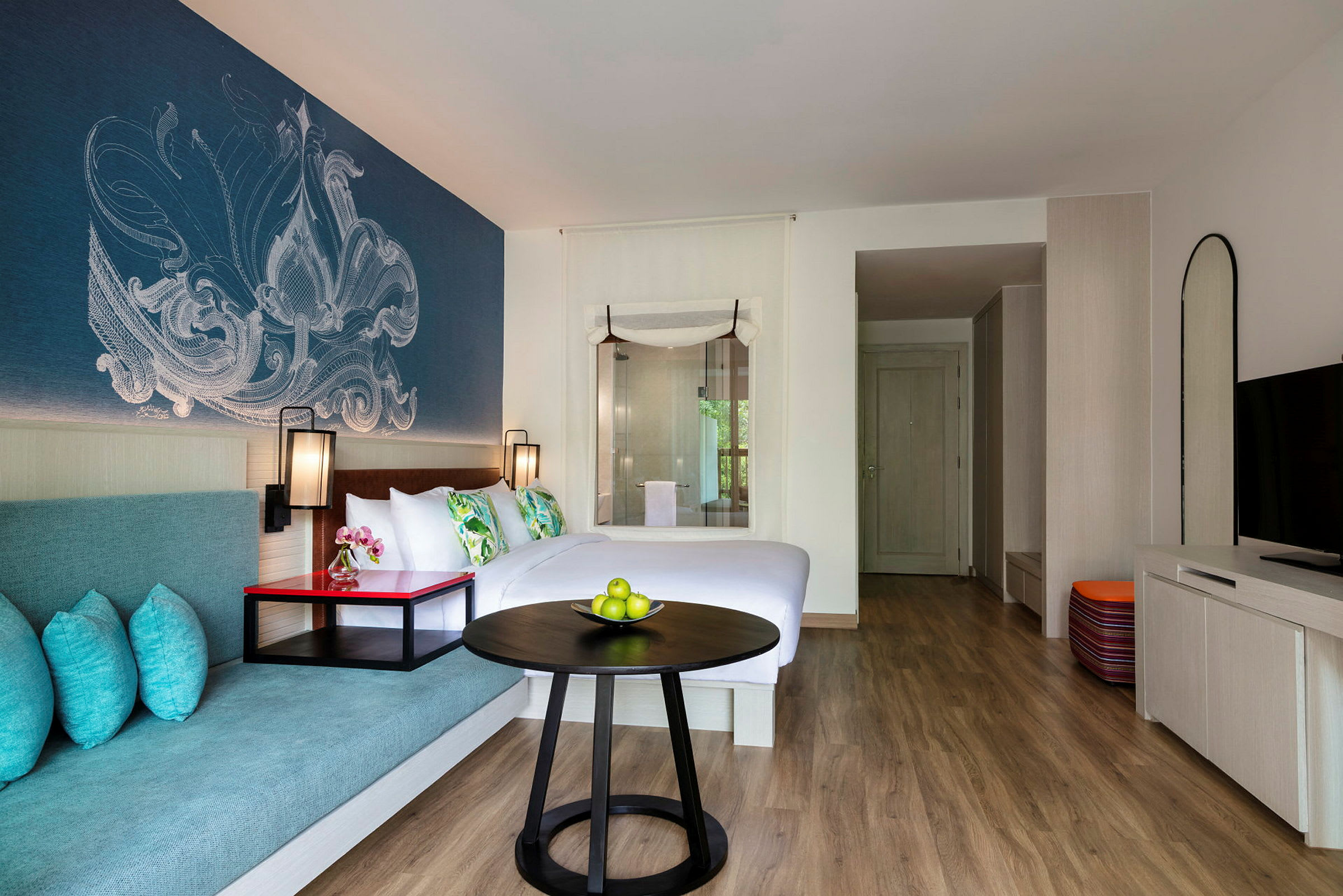 Hotellihuone, jossa parivuode, istuinalue ja koristeellinen seinäsuunnittelu. (Tekoälyn luoma teksti)