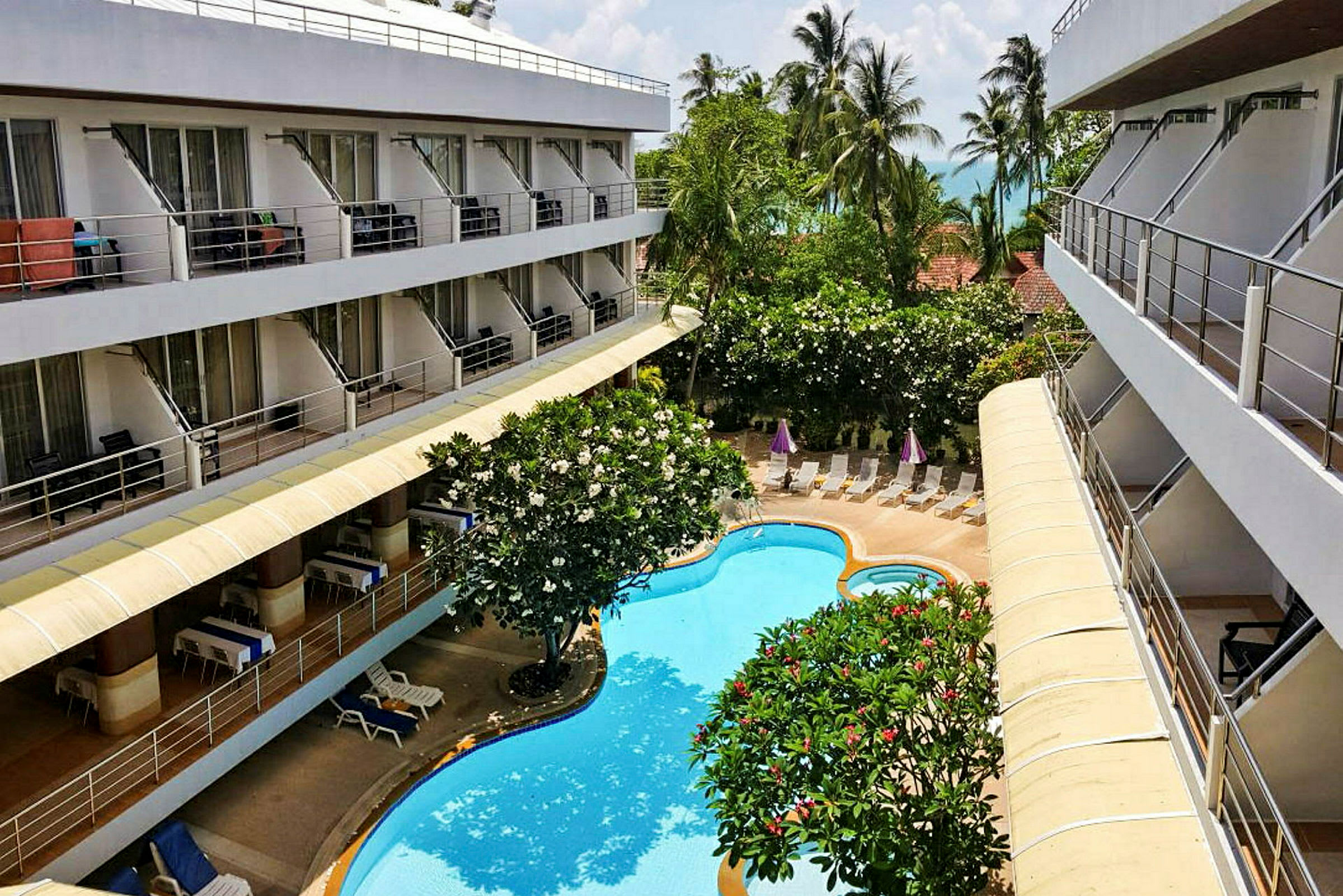 Kuva hotellista, jossa on parvekkeita, puutarha ja uima-allas. (Tekoälyn luoma teksti)