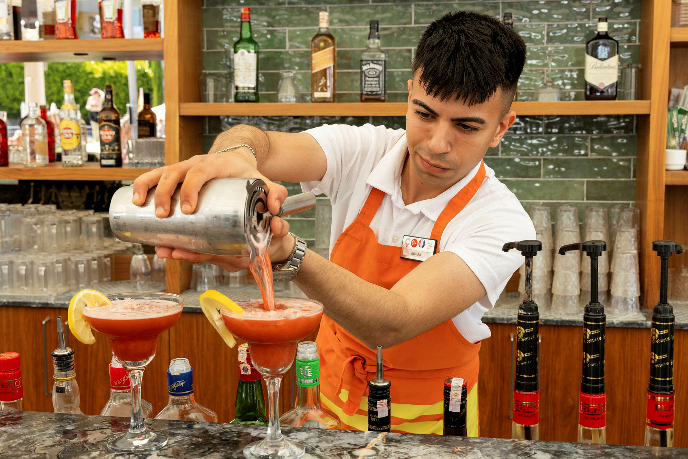 Baarimikko kaataa punaista juomaa cocktail-lasiin. (Tekoälyn luoma teksti)