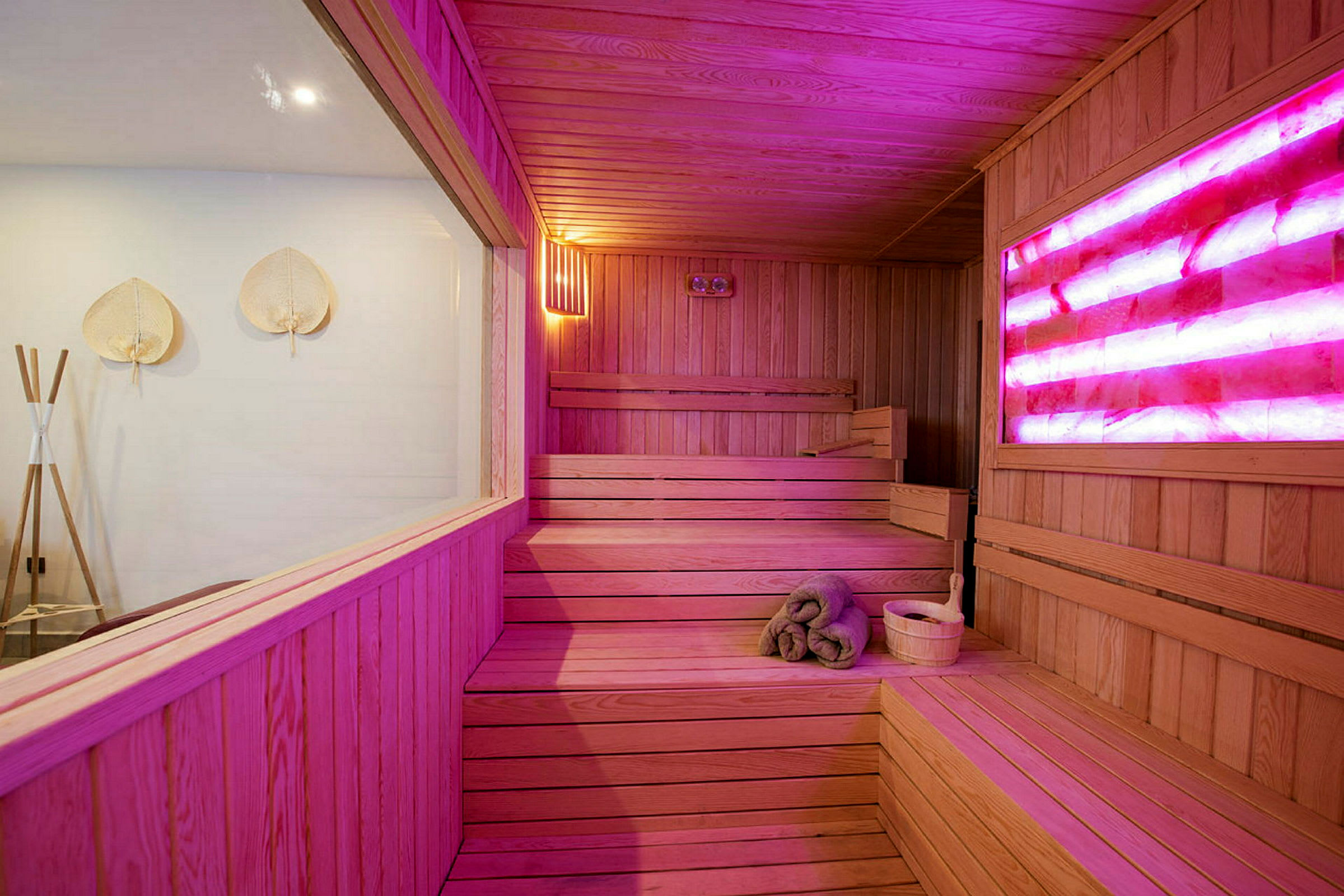 Sauna, jossa on puinen sisustus ja värikäs valaistus. (Tekoälyn luoma teksti)