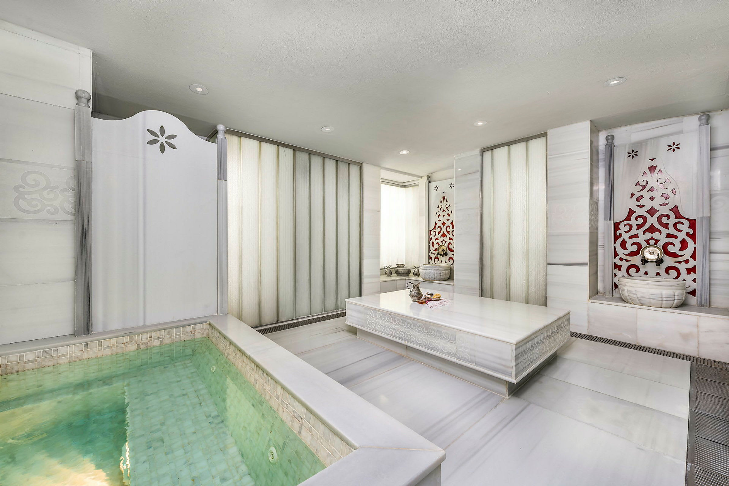 Spa-huone, jossa on pieni uima-allas ja koristellut seinät. (Tekoälyn luoma teksti)