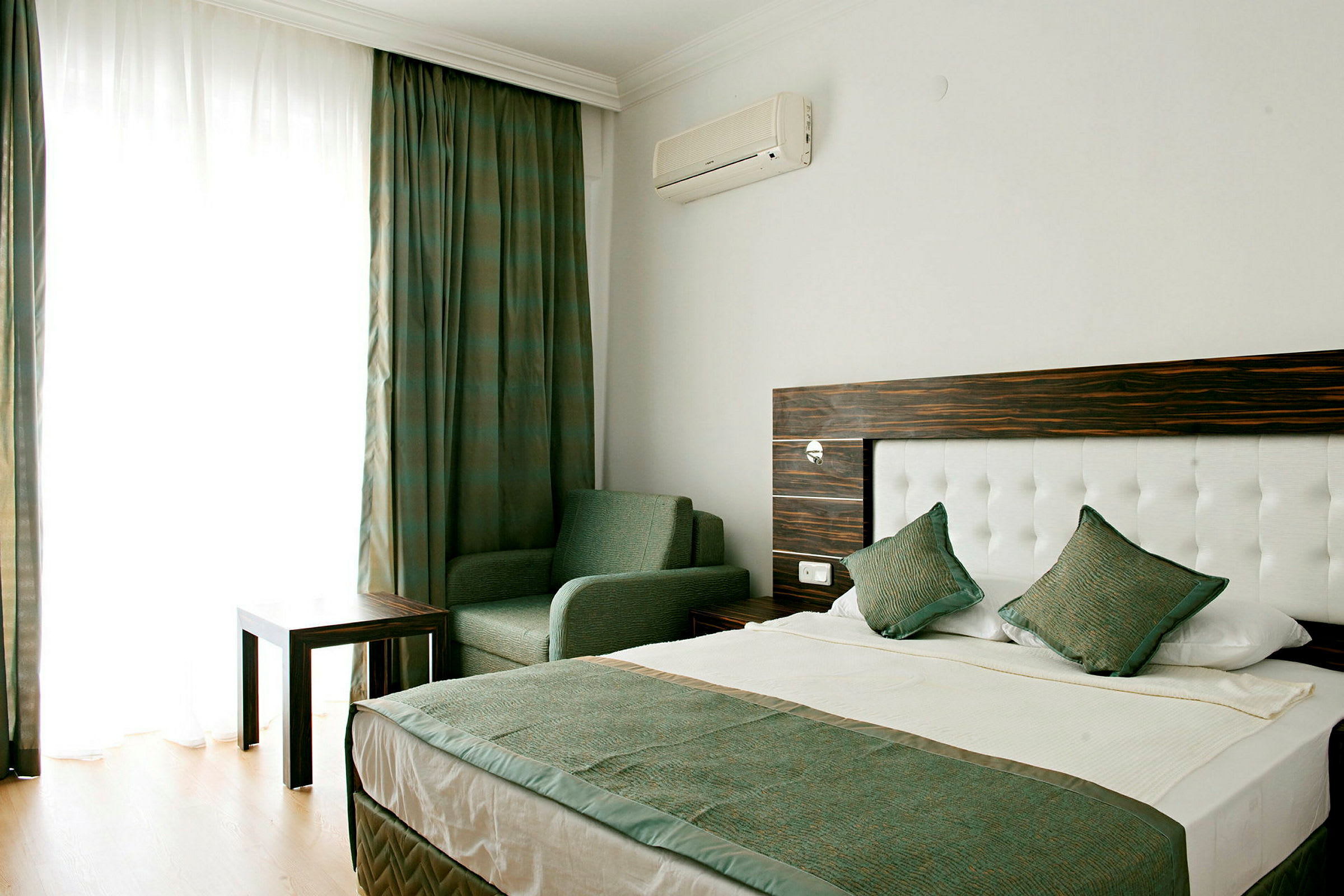 Hotellihuone, jossa on sänky, tuoli ja pöytä. (Tekoälyn luoma teksti)