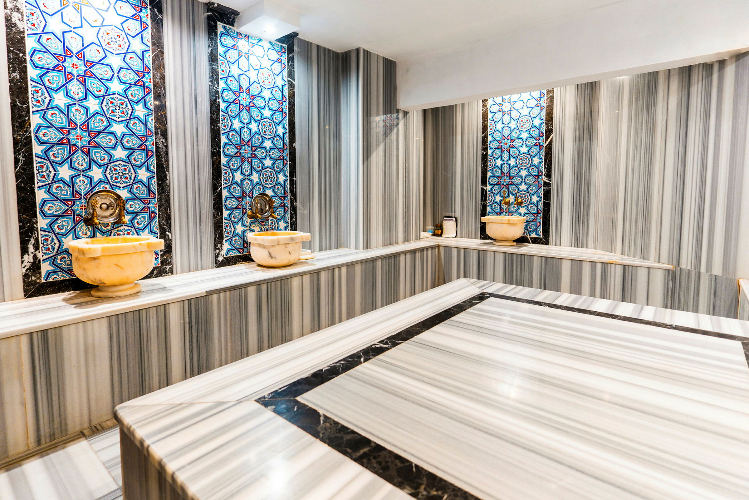 Perinteinen hamam, jossa on marmoripinnat ja siniset mosaiikkikoristeet seinillä. (Tekoälyn luoma teksti)