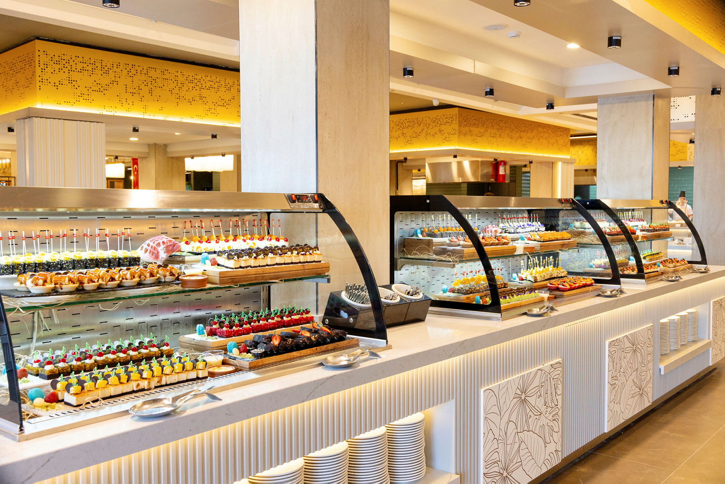 Buffet, jossa on erilaisia jälkiruokia ja leivonnaisia valoisassa huoneessa. (Tekoälyn luoma teksti)