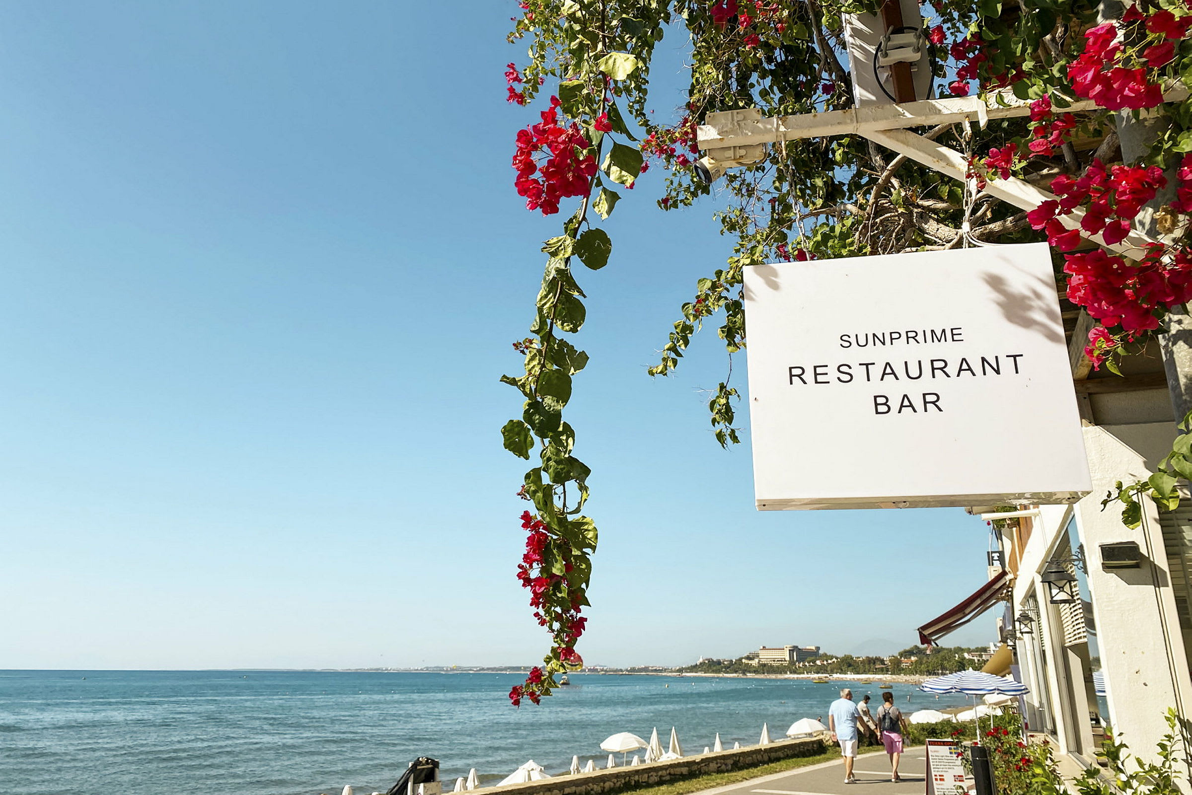 Sunprime Restaurant Barin kyltti merenrannan lähellä. (Tekoälyn luoma teksti)