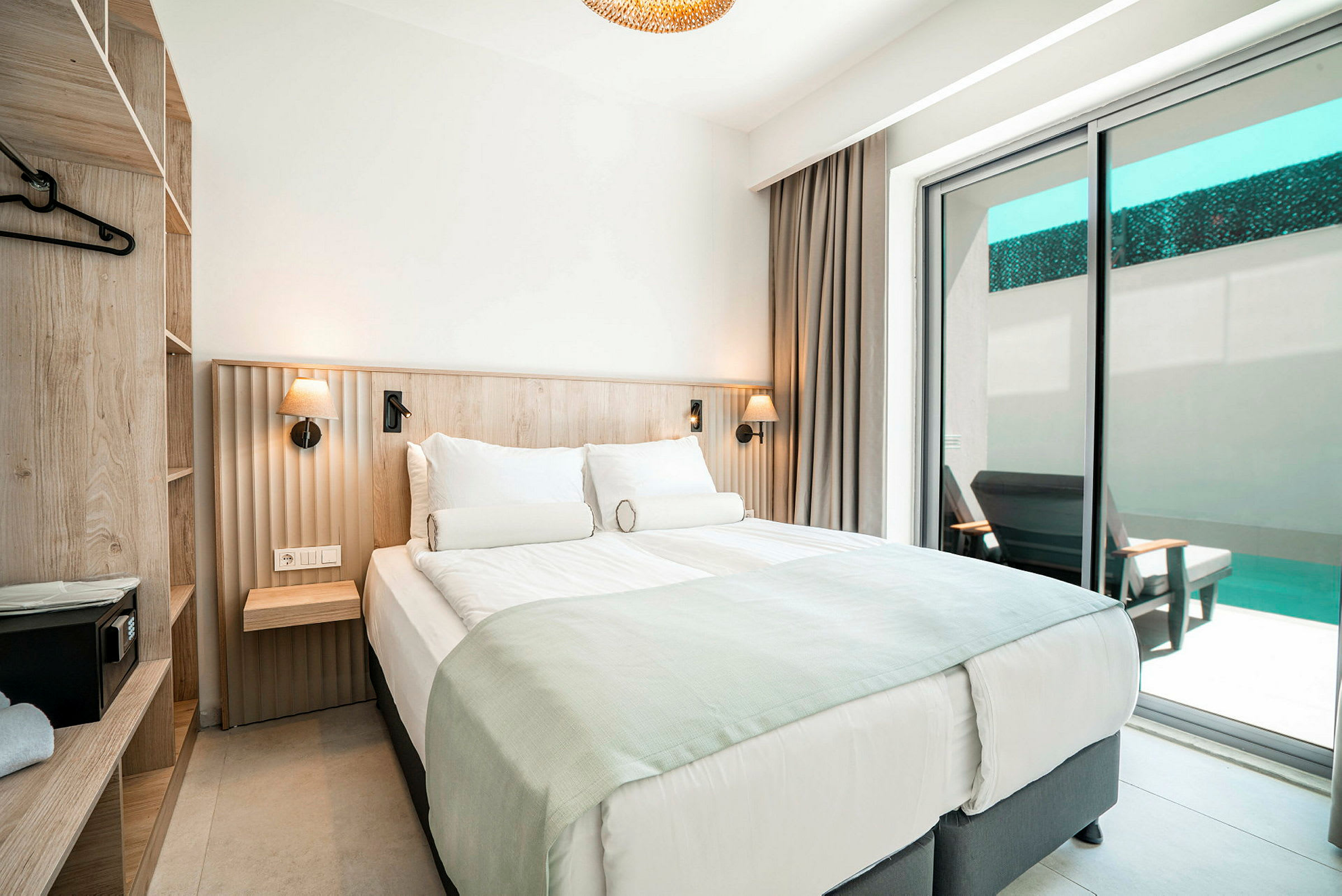 Hotellihuone, jossa on parivuode, laatikot ja parveke näkymällä uima-altaalle. (Tekoälyn luoma teksti)
