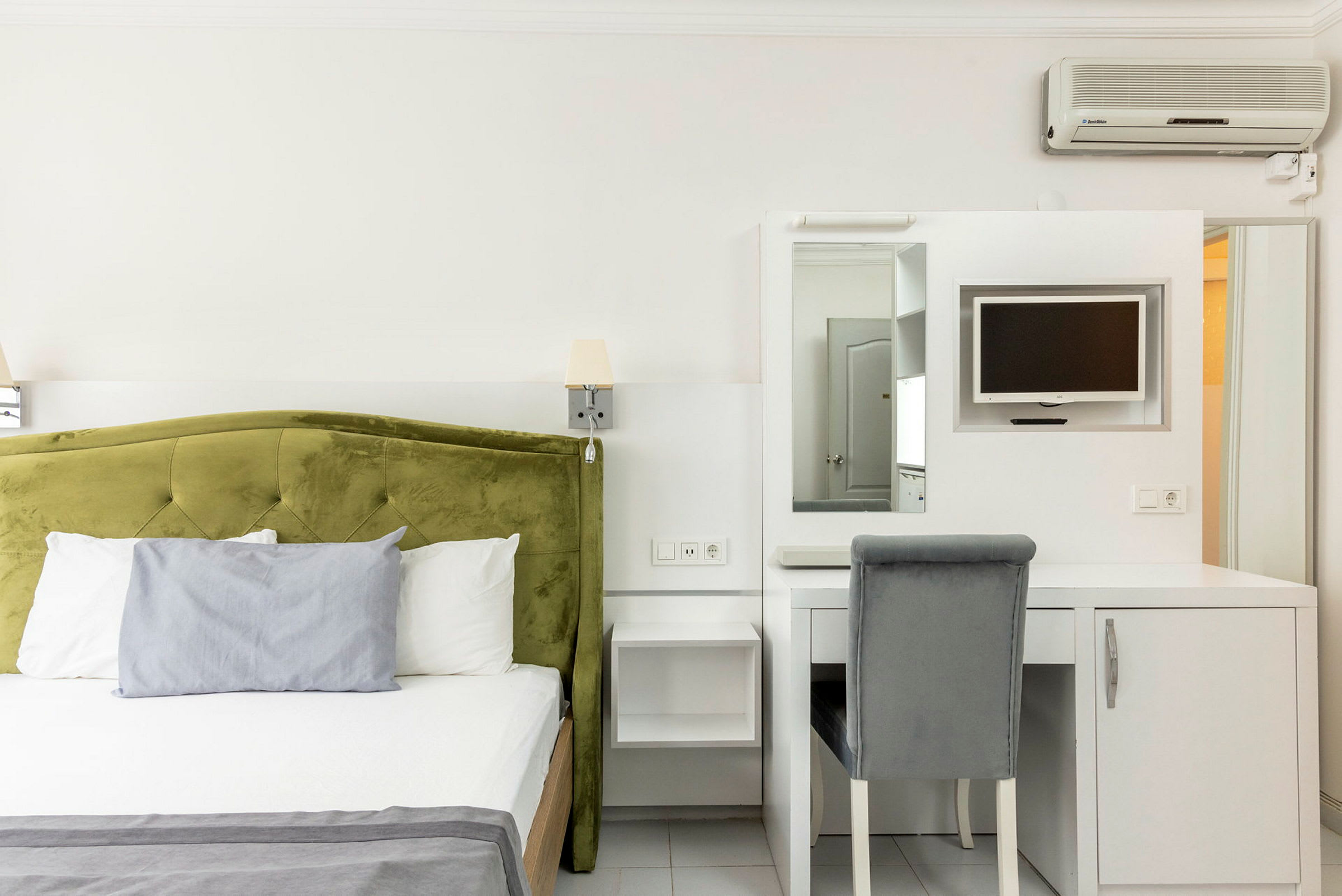 Hotellihuone, jossa sänky ja kirjoituspöytä tuolilla. (Tekoälyn luoma teksti)