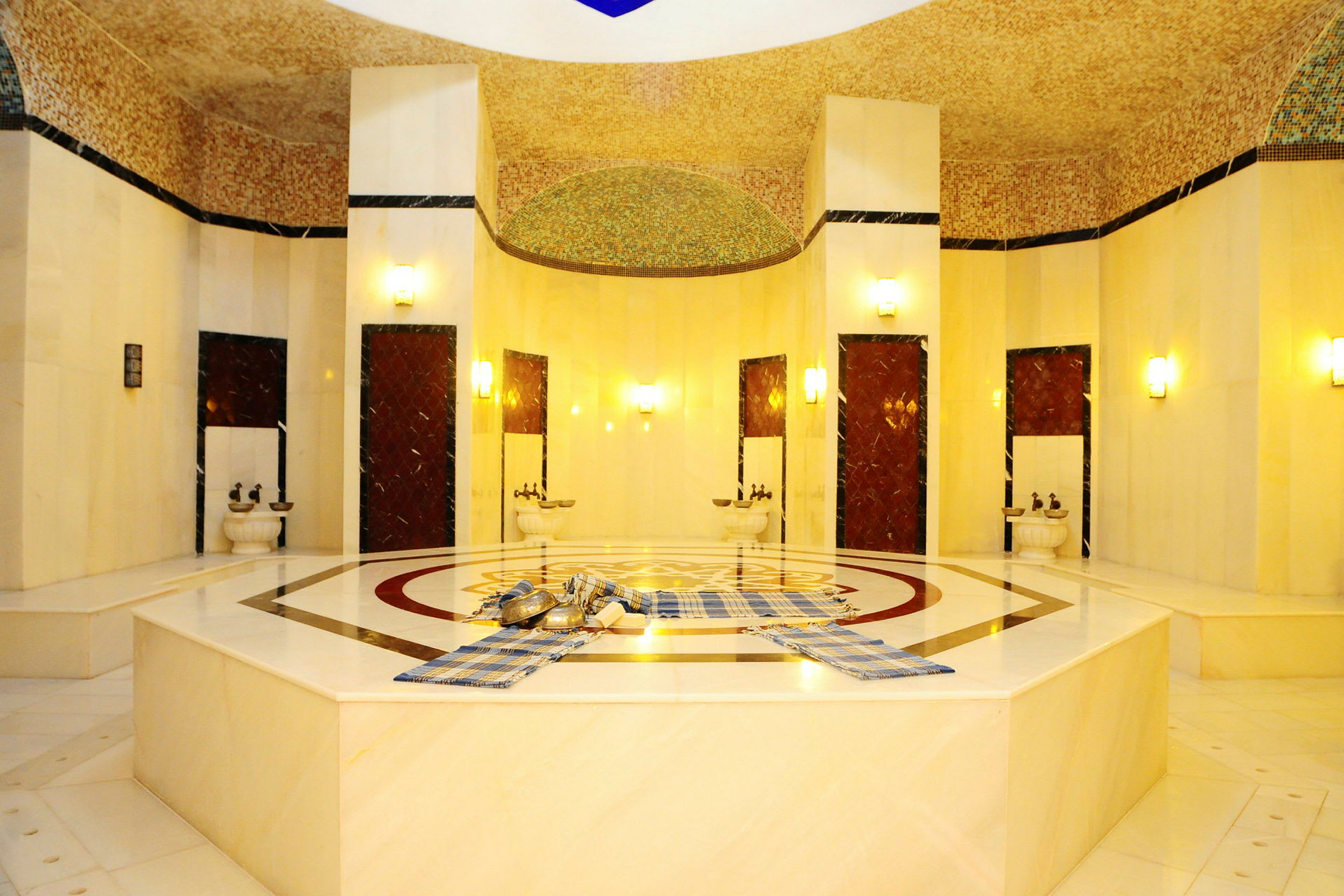 Perinteinen turkkilainen hamam, jossa on marmorialustoja ja geometrisia kuvioita. (Tekoälyn luoma teksti)