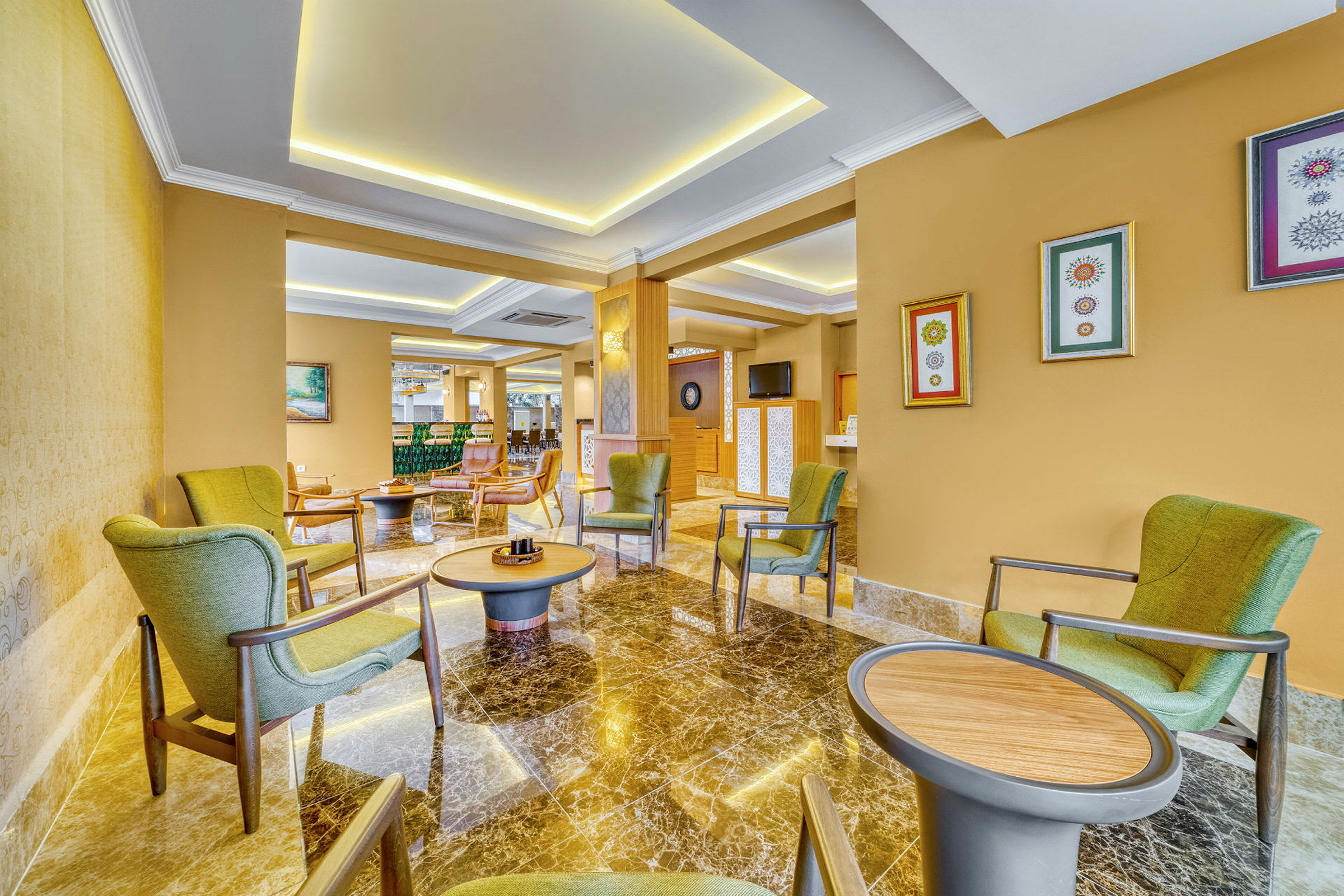 Moderni hotellihuone, jossa on marmorilattia ja vihreitä nojatuoleja. (Tekoälyn luoma teksti)