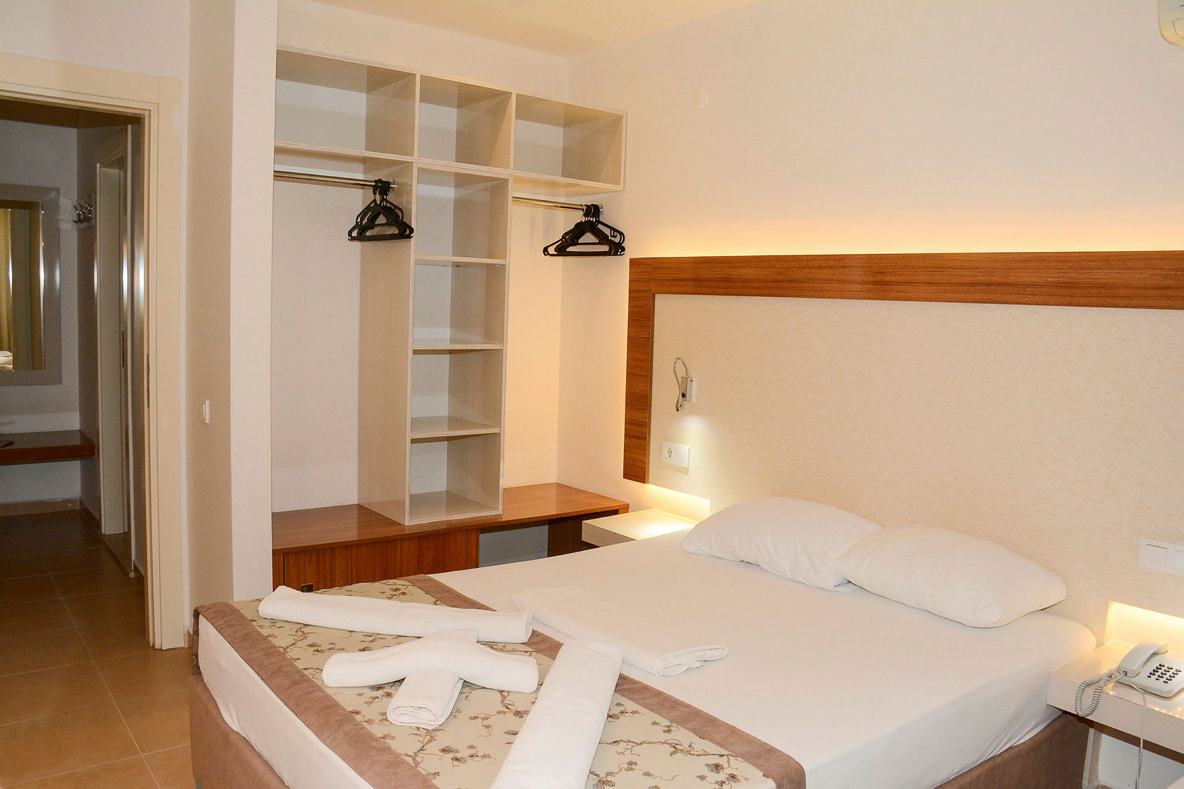 Hotellihuone, jossa parivuode, vaatekaappi ja yöpöytä. (Tekoälyn luoma teksti)
