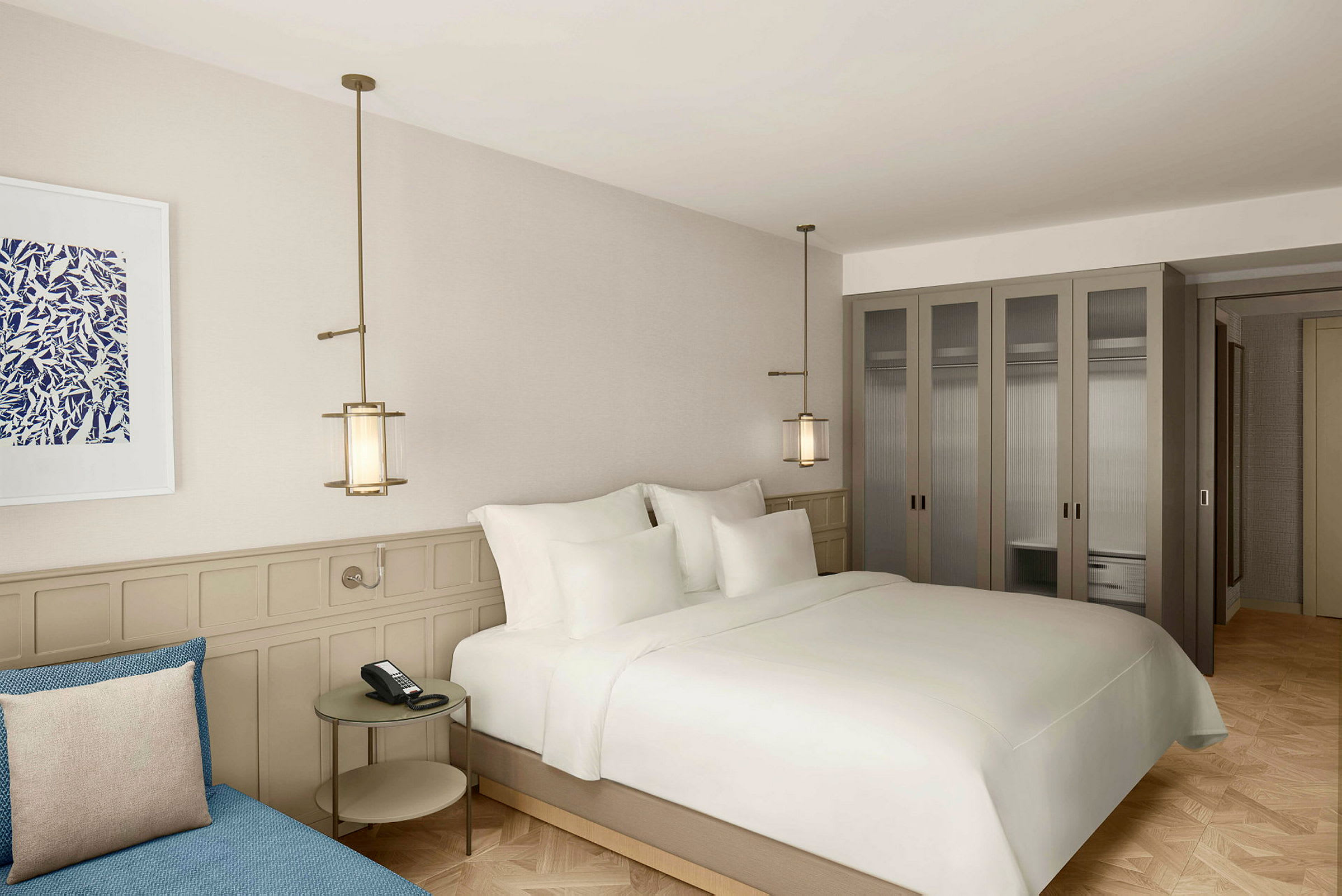 Moderni hotellihuone, jossa suuri sänky, sohvapöytä ja vaatekaapit. (Tekoälyn luoma teksti)