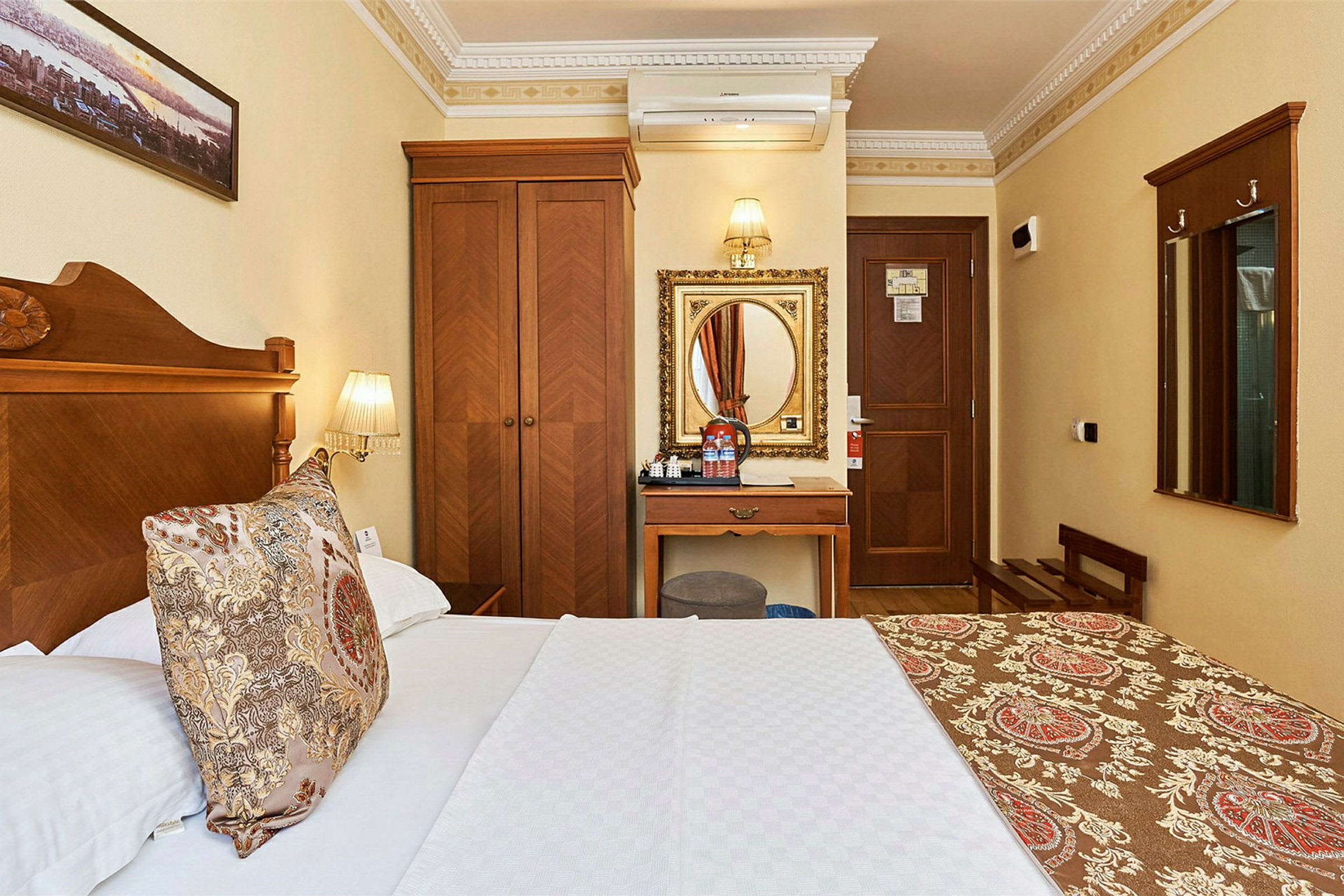 Hotellihuone, jossa on puukalusteita ja sänky, jonka päällä kuvioitu päiväpeite. (Tekoälyn luoma teksti)