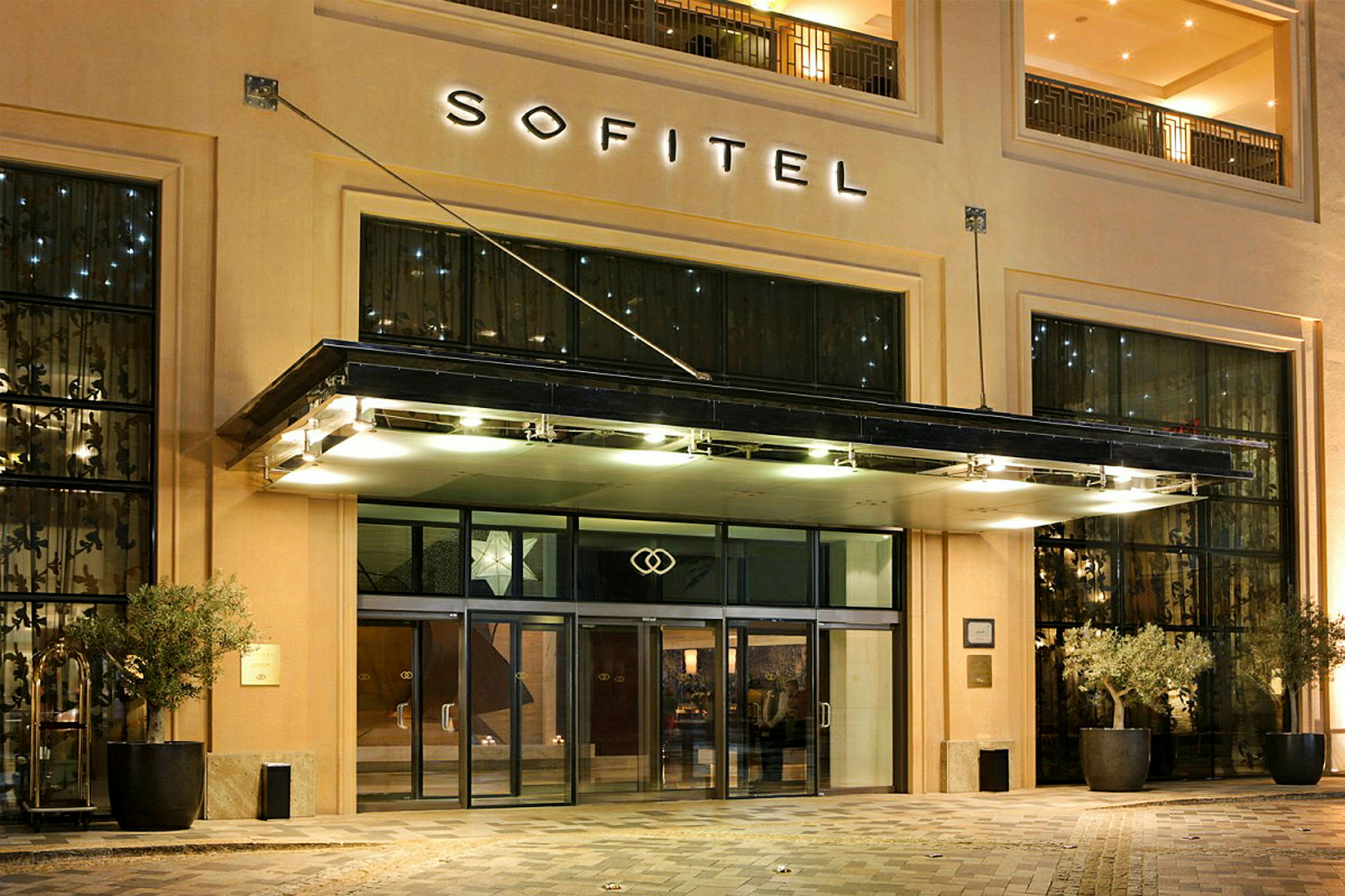 Sofitel-hotellin sisäänkäynti lasiovilla ja valaistuksella. (Tekoälyn luoma teksti)