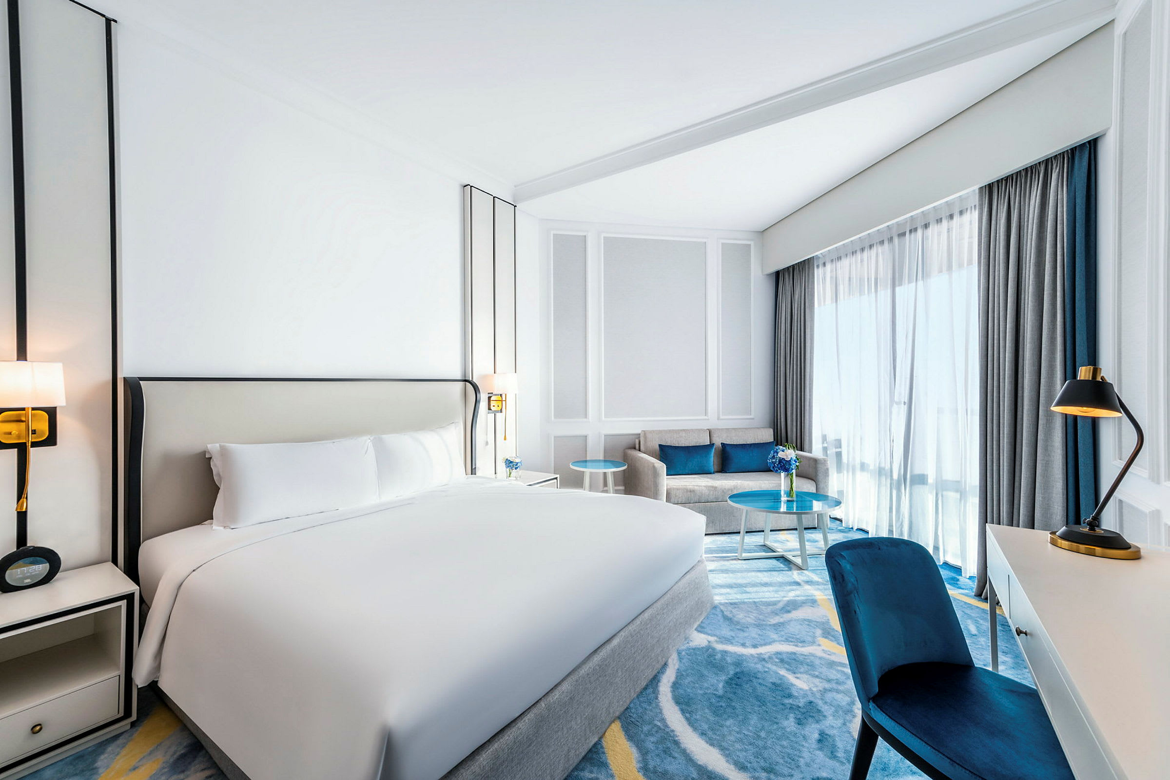 Hotellihuone, jossa on parivuode, sohva ja työpöytä. (Tekoälyn luoma teksti)