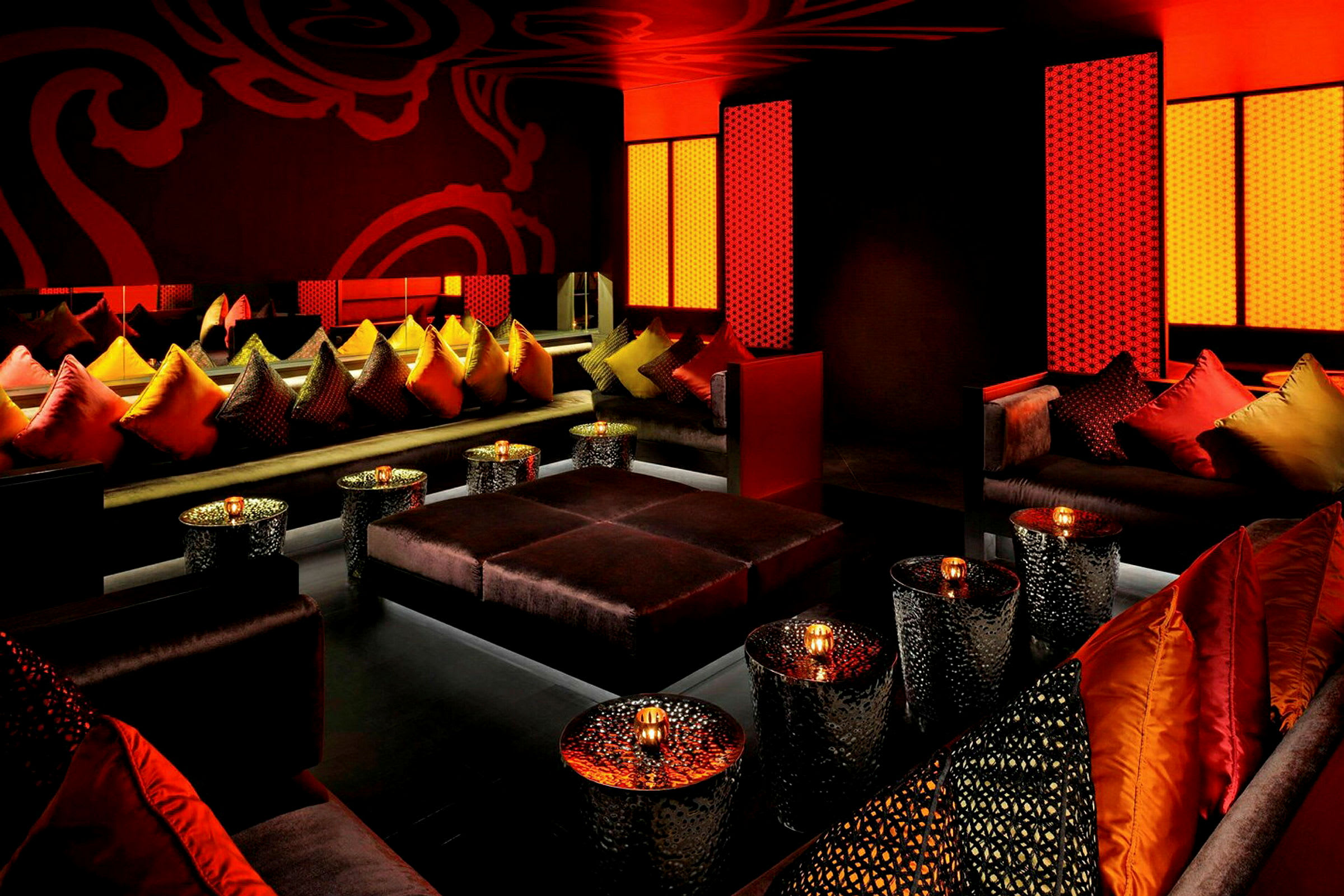 Kodikas lounge värikkäillä tyynyillä ja modernit pöydät kynttilöillä. (Tekoälyn luoma teksti)