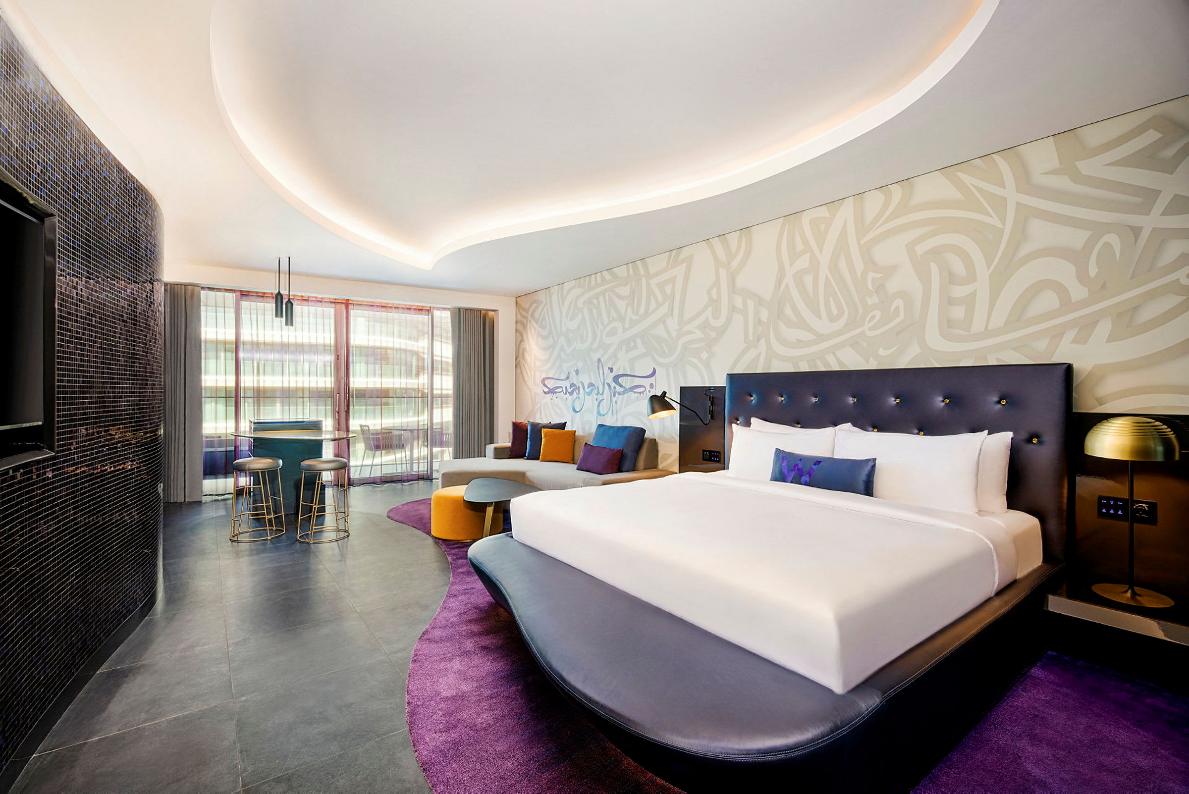 Modernisti sisustettu hotellihuone, jossa suuri sänky ja oleskelualue. (Tekoälyn luoma teksti)