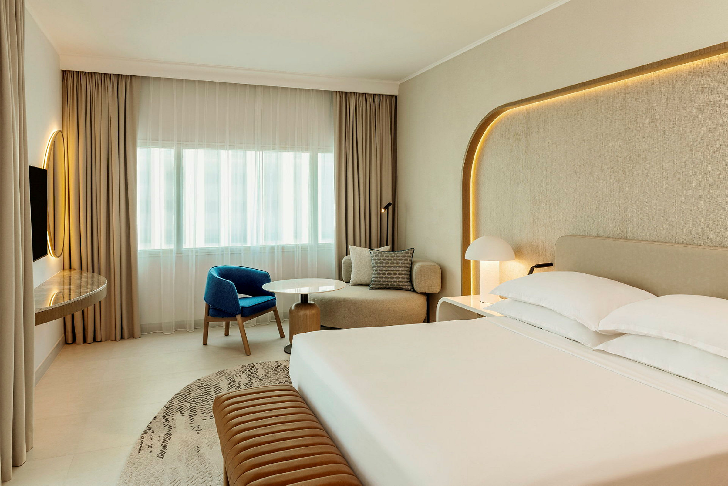 Nykyaikainen hotellihuone, jossa iso sänky, oleskelutila ja kirjoituspöytä. (Tekoälyn luoma teksti)