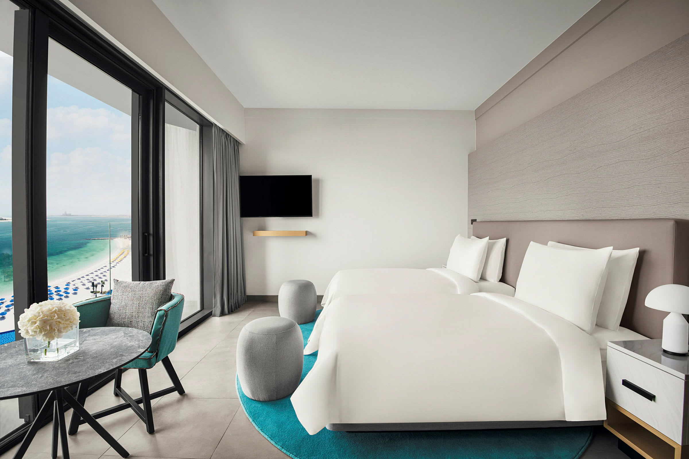 Hotellihuone, jossa kaksi sänkyä ja näkymä merelle. (Tekoälyn luoma teksti)