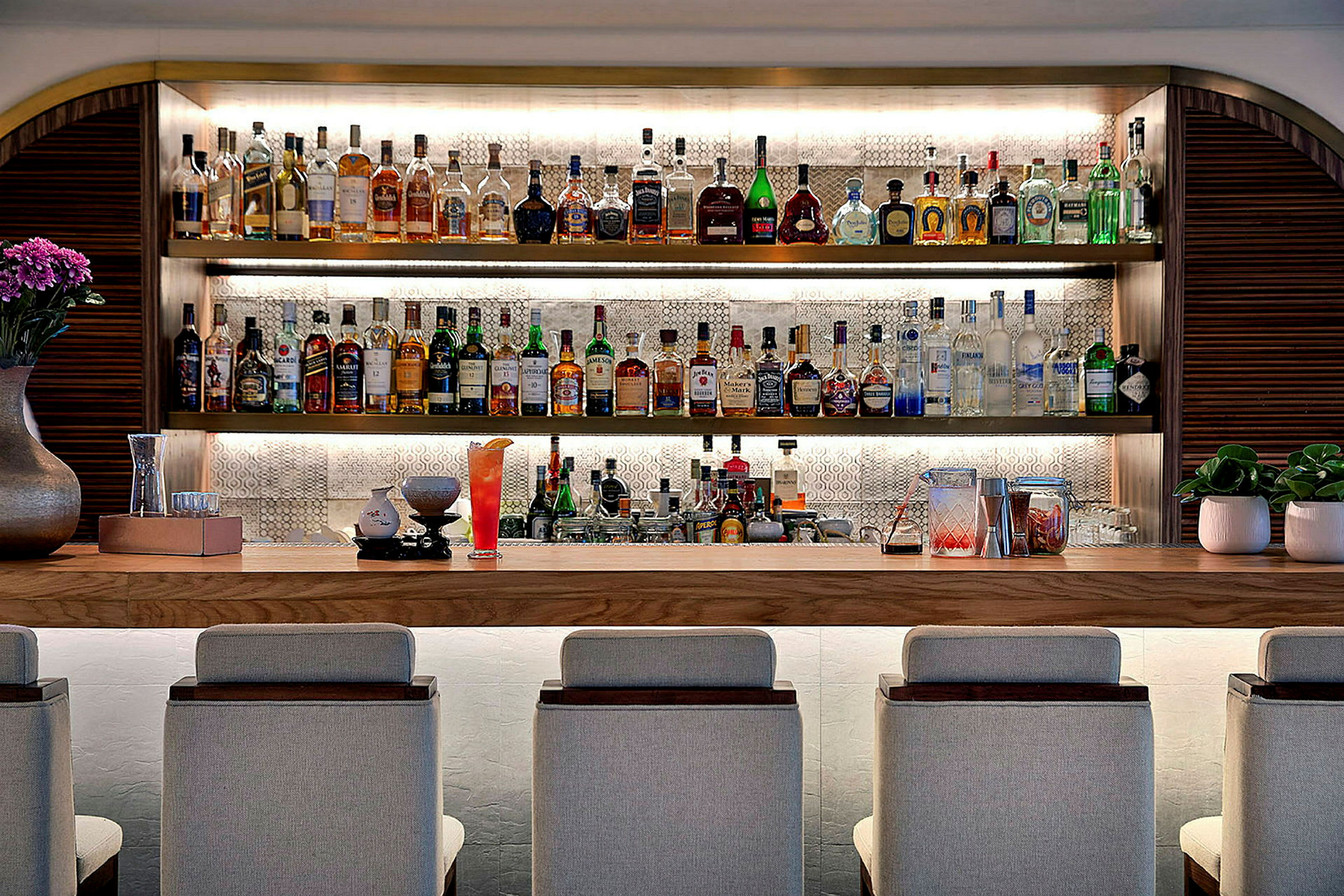 Hyvin varusteltu baaritiski istuinpaikoilla, alkoholipulloilla ja koristeluilla. (Tekoälyn luoma teksti)