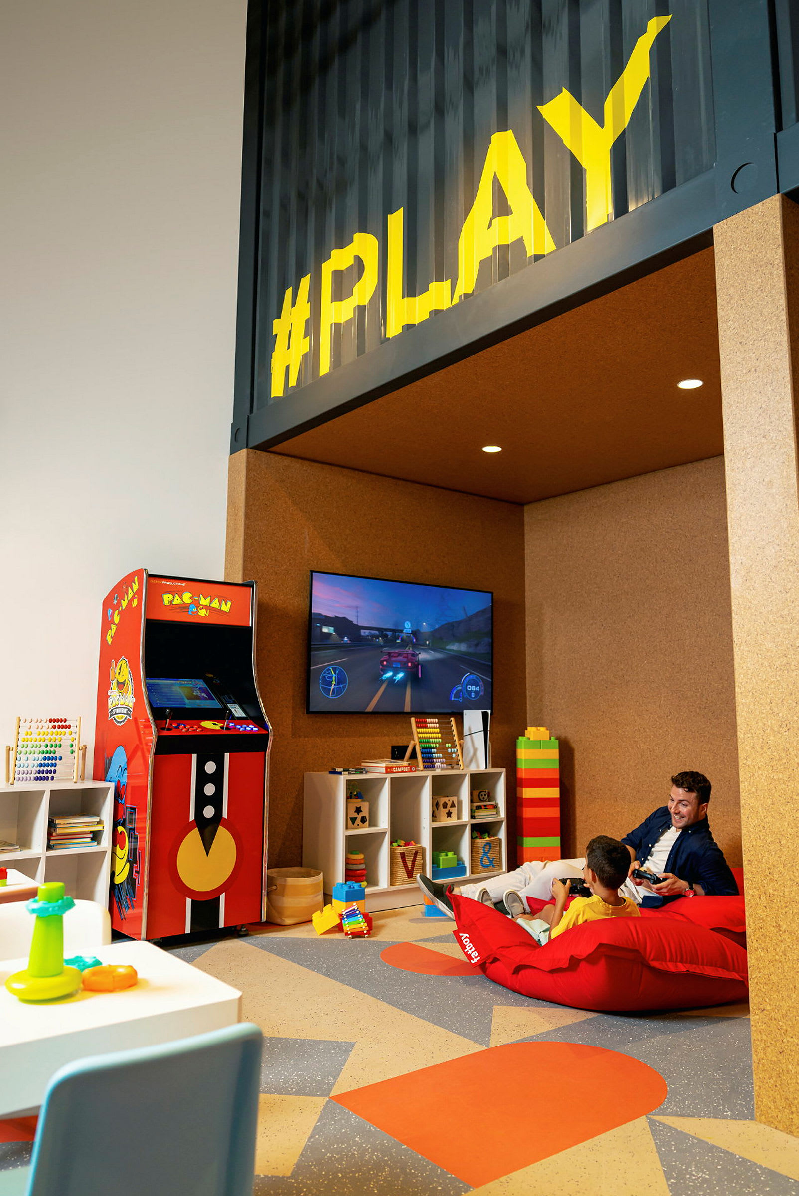 Leikkihuone, jossa pelinurkkaus sisältäen arcade-pelin ja televisiopelin. (Tekoälyn luoma teksti)