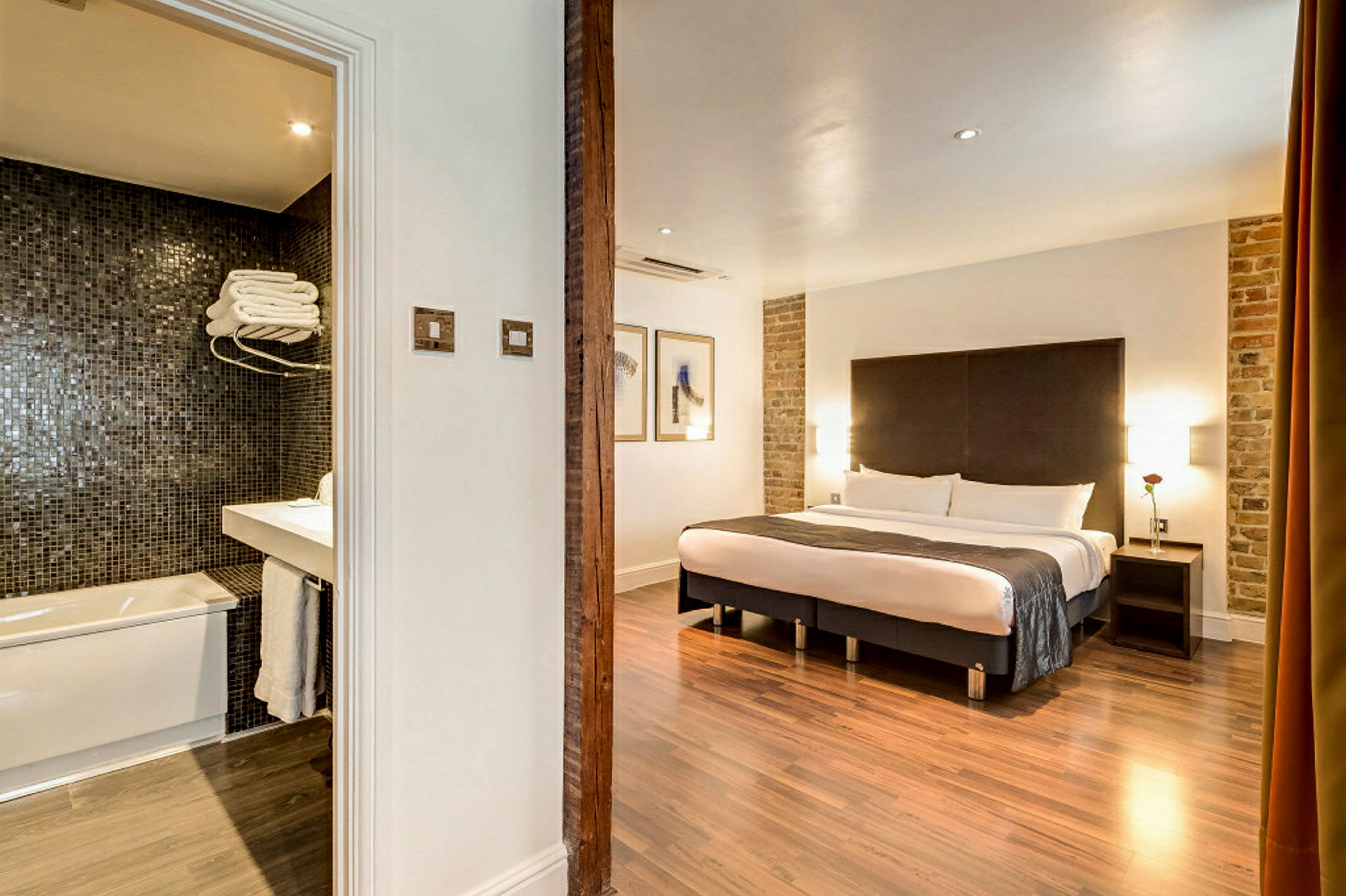 Hotellihuone, jossa parivuode ja viereinen kylpyhuone. (Tekoälyn luoma teksti)