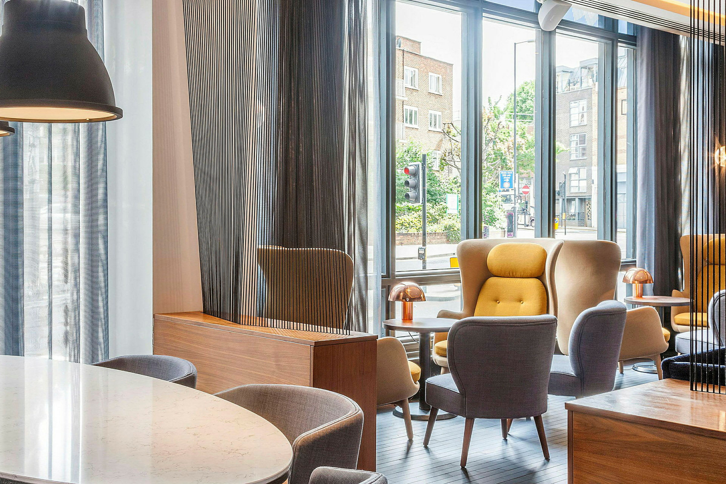Moderni lounge, jossa on suuret ikkunat ja mukavat istuimet. (Tekoälyn luoma teksti)