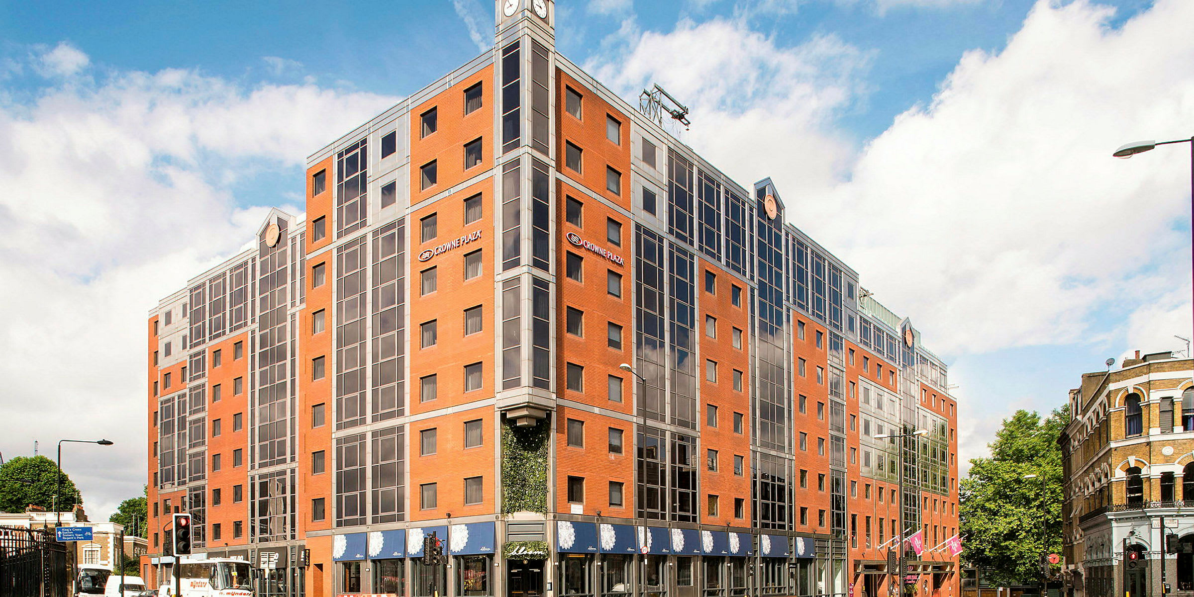 Kuva hotellista, jossa on punatiiliä ja lasi-ikkunoita. (Tekoälyn luoma teksti)