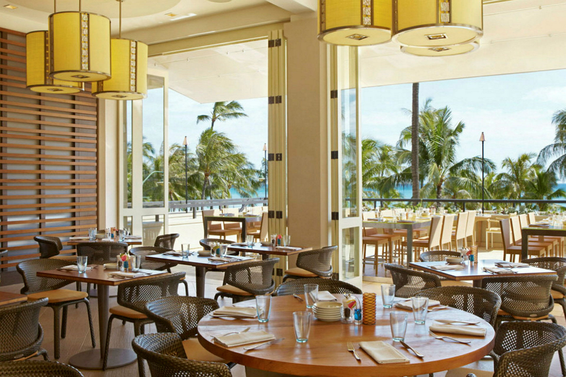 Ravintola, jossa on ulkoterassi ja näkymä palmupuihin ja merelle. (Tekoälyn luoma teksti)