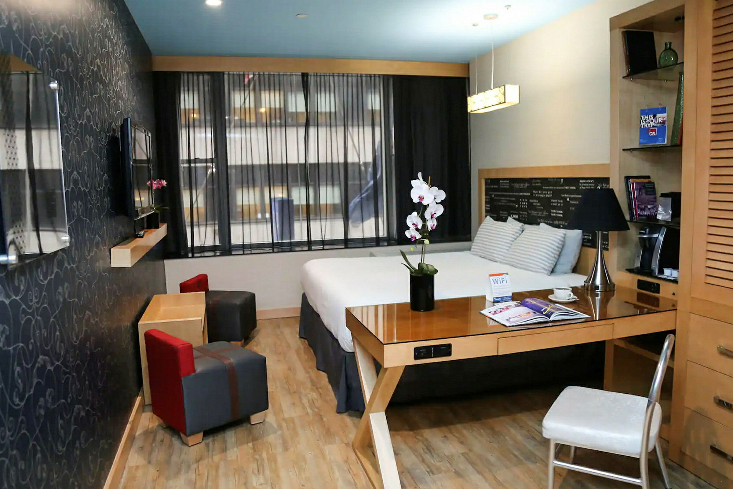 Moderni hotellihuone, jossa on parivuode, työpöytä ja oleskelualue. (Tekoälyn luoma teksti)