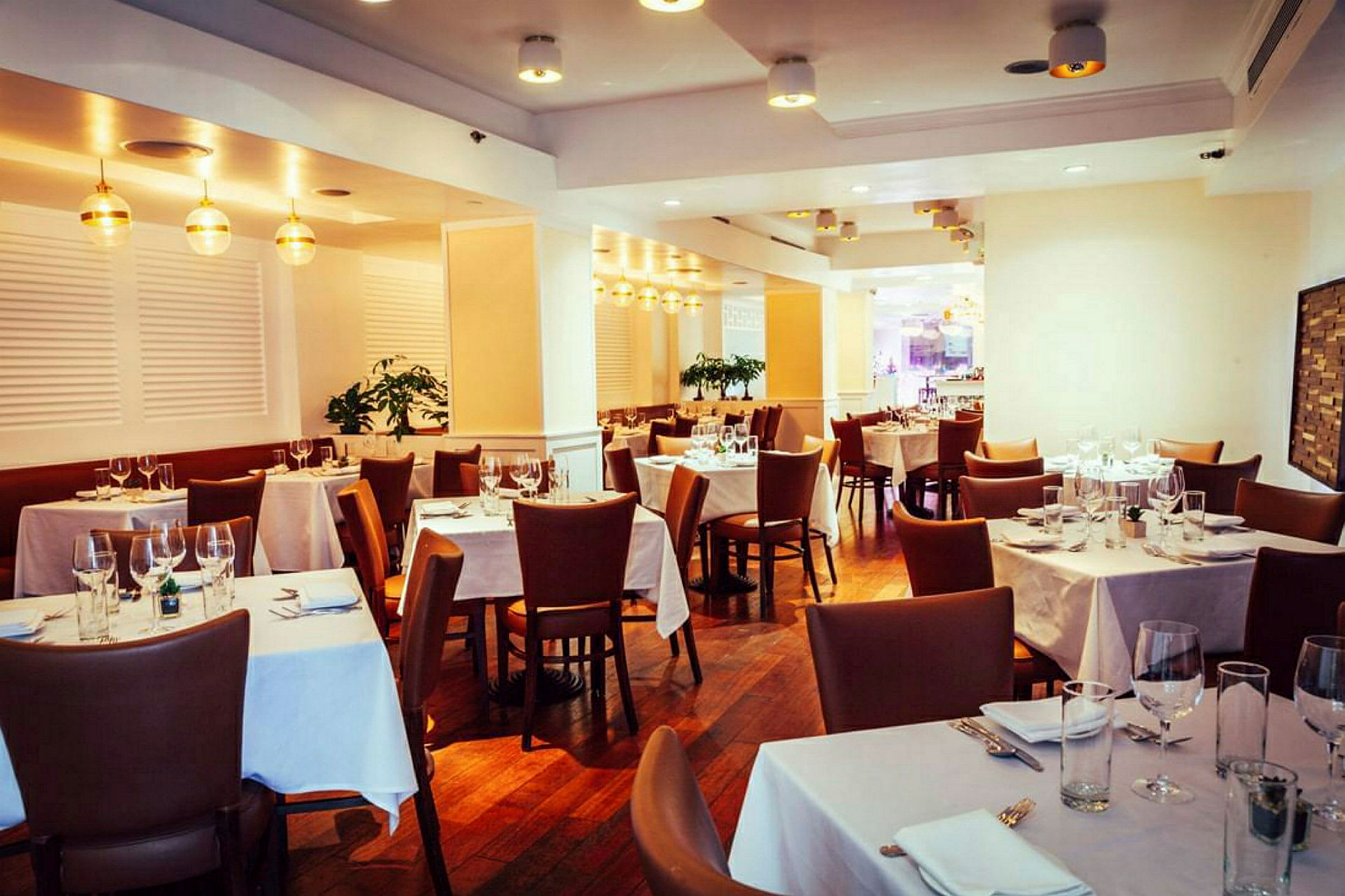Tyylikäs ravintola, jossa katetut pöydät ja ruskeat tuolit. (Tekoälyn luoma teksti)