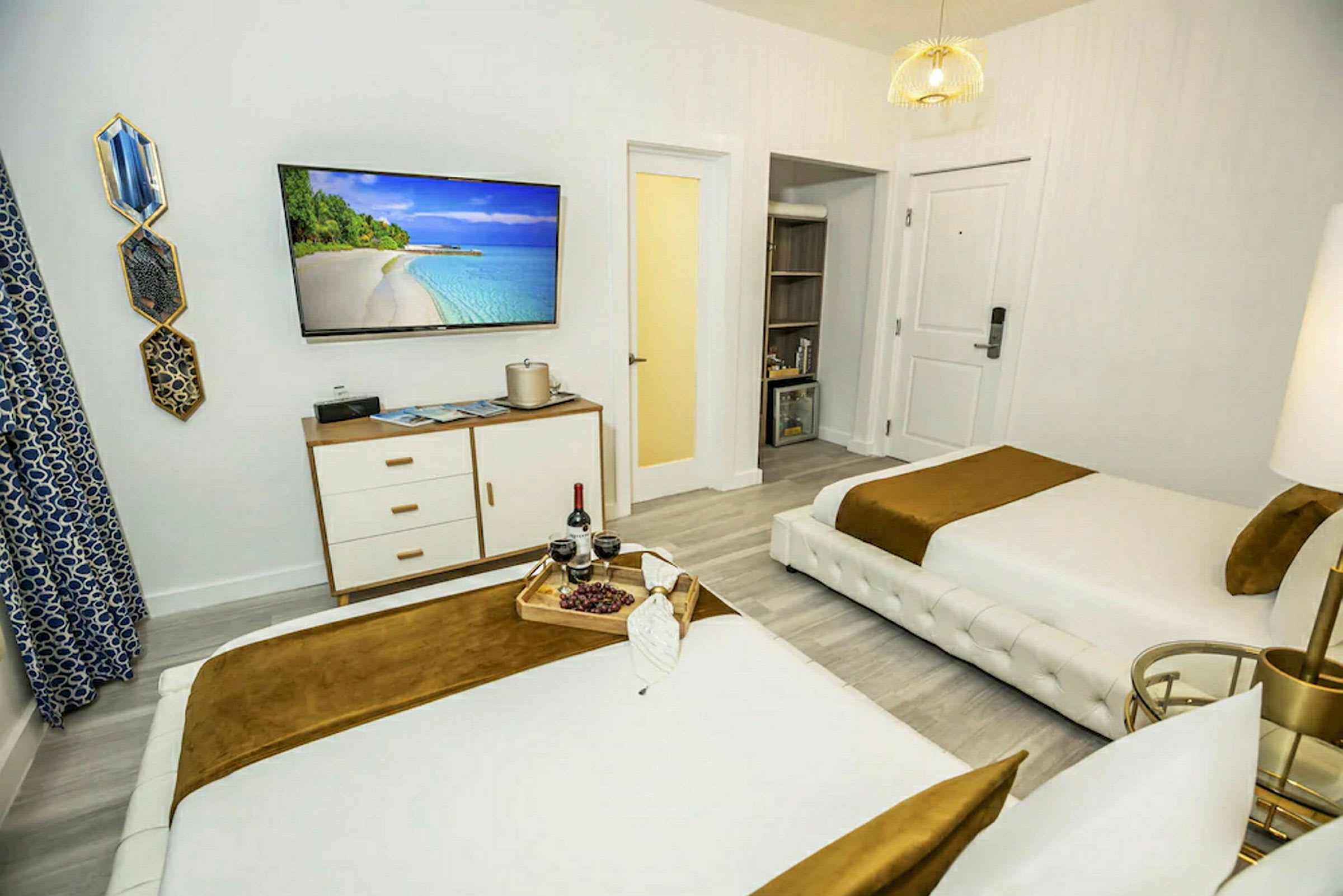 Hotellihuone, jossa on kaksi vuodetta, televisio ja koristeellinen pöytä. (Tekoälyn luoma teksti)