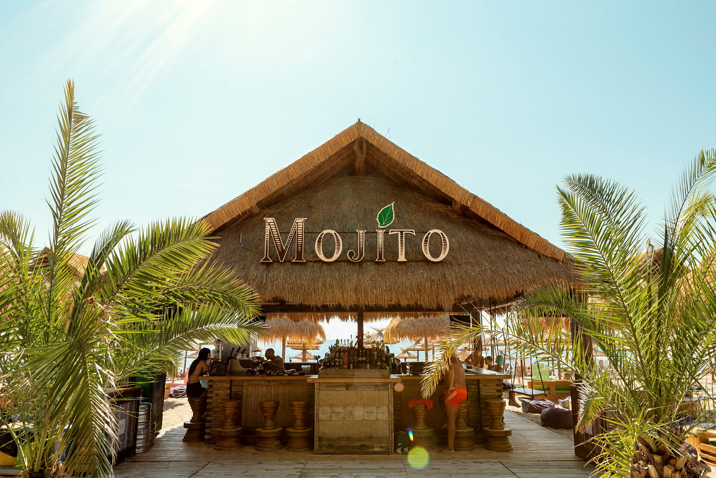 Olkikattoinen rantabaari, jonka nimi on Mojito. (Tekoälyn luoma teksti)