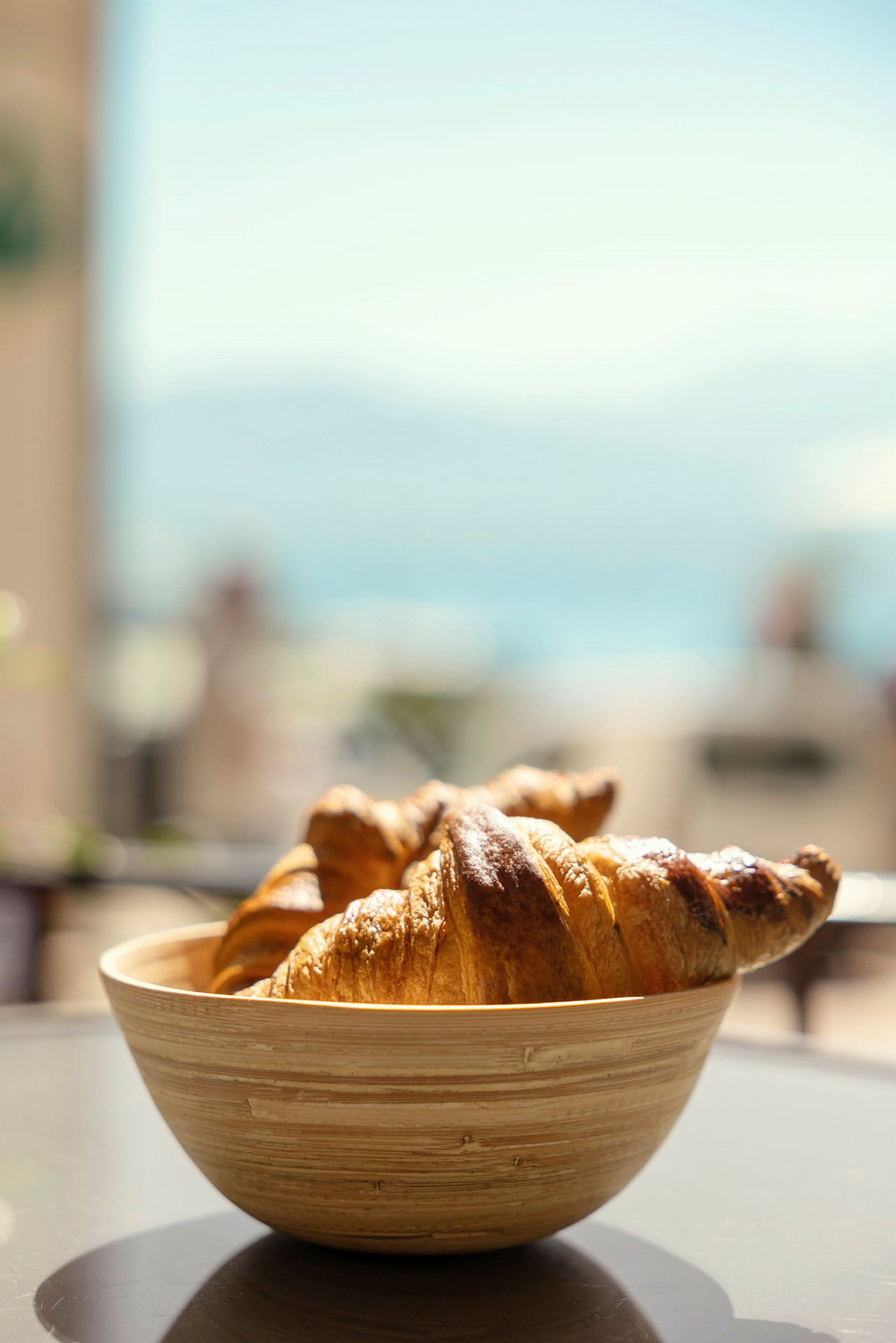 Kulhossa olevat croissantit pöydällä, tausta on sumea. (Tekoälyn luoma teksti)