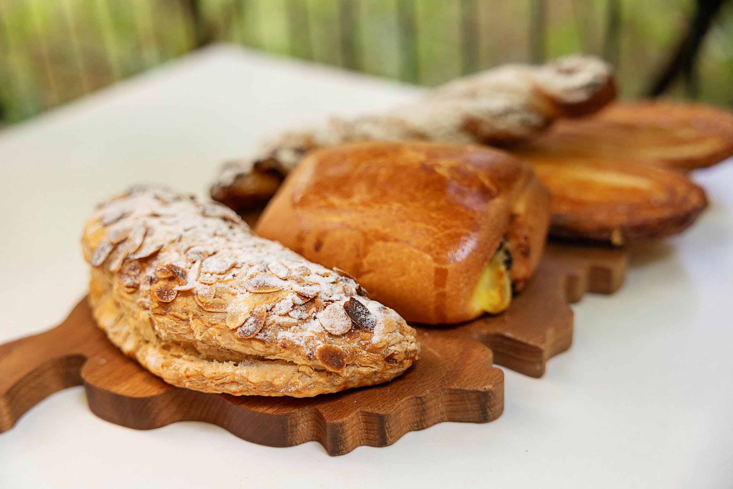 Puisella tarjottimella erilaisia leivonnaisia, kuten mantelicroissant tomusokerilla. (Tekoälyn luoma teksti)
