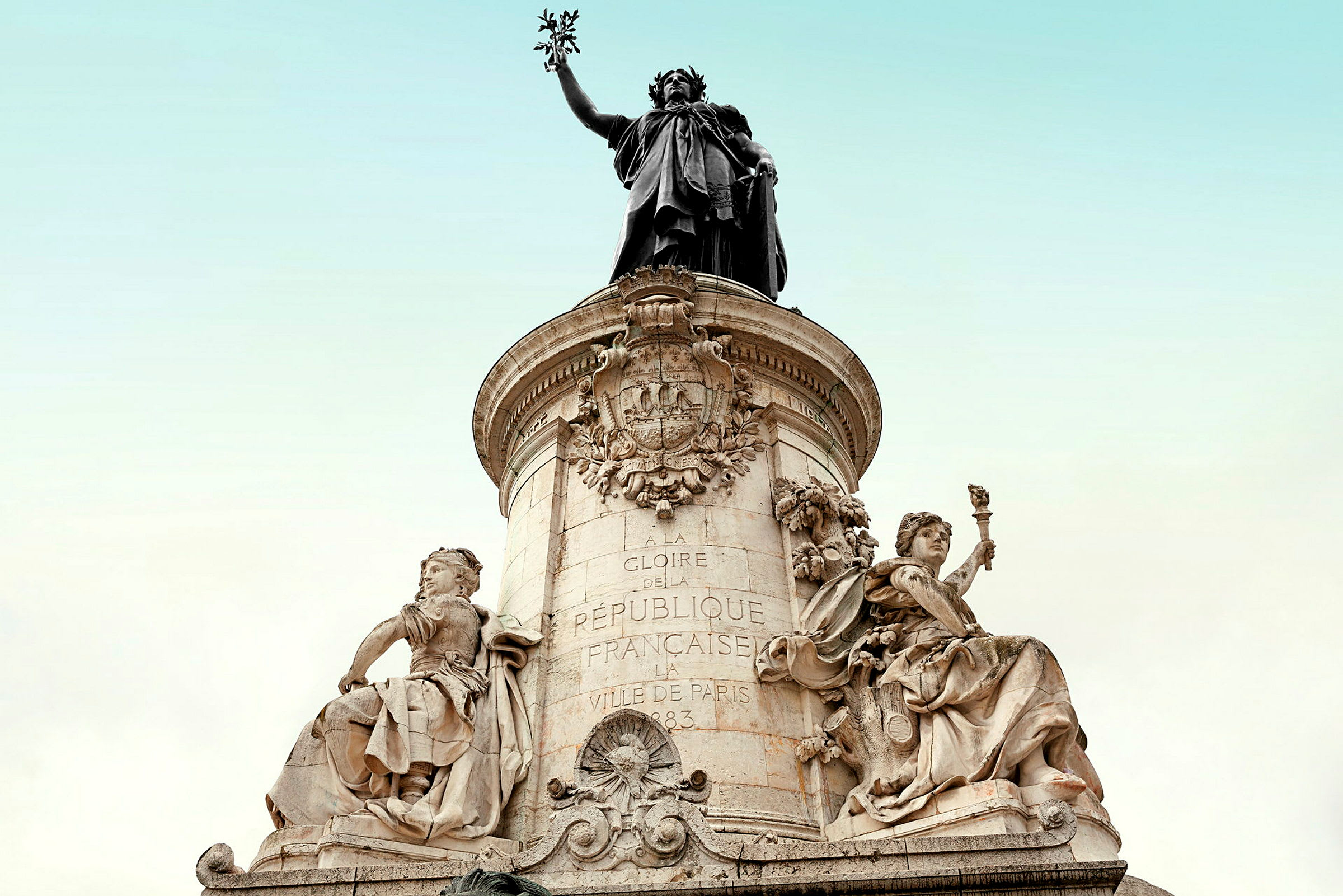 Patsas, jossa yksityiskohtaisia taideteoksia ja kaiverruksia kiviaskelmalla kirkkaan taivaan taustaa vasten. (Tekoälyn luoma teksti)