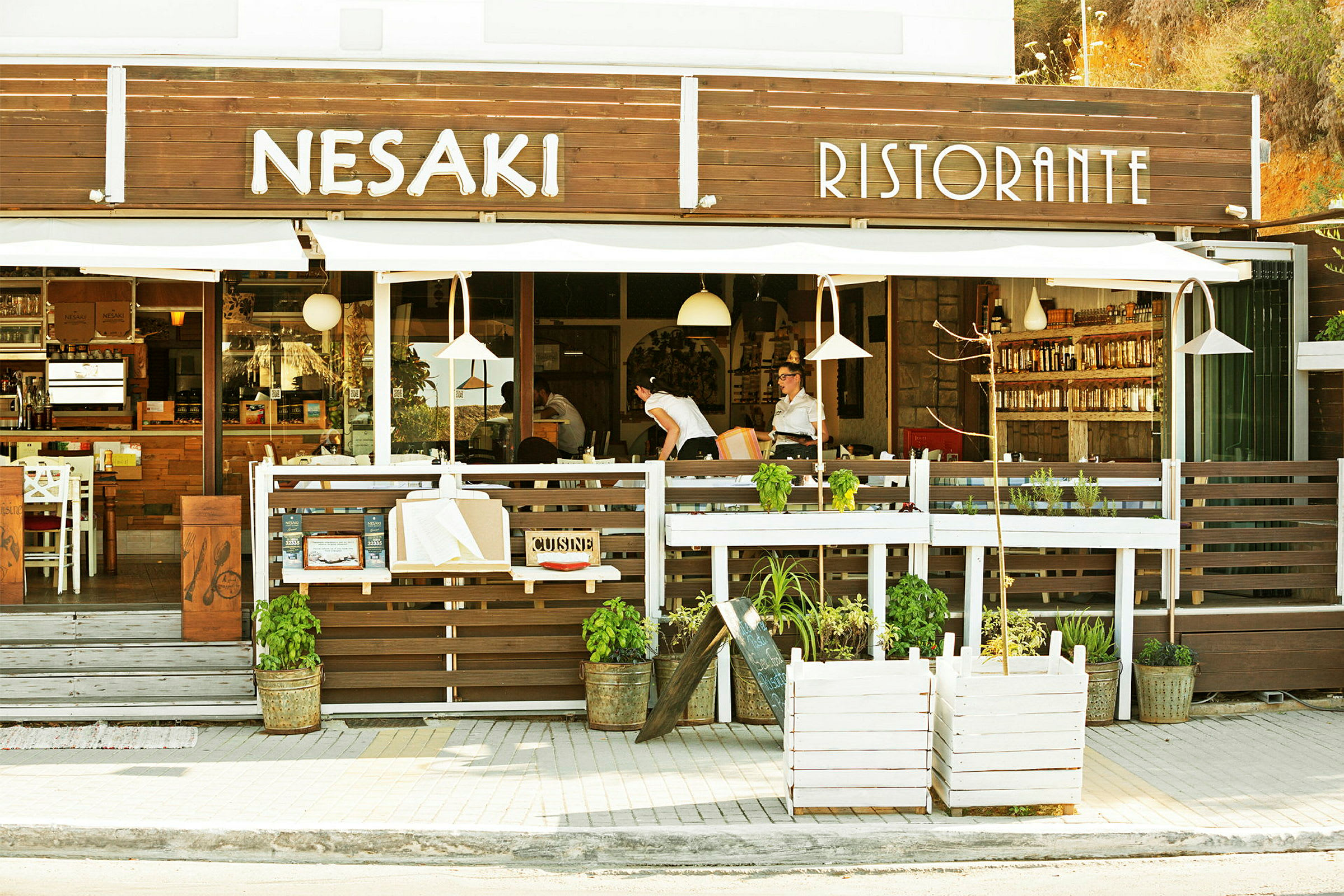 Kuvassa ravintolan julkisivu, jossa tekstinä "Nesaki Ristorante", ja ulkoilmaruokailualue. (Tekoälyn luoma teksti)