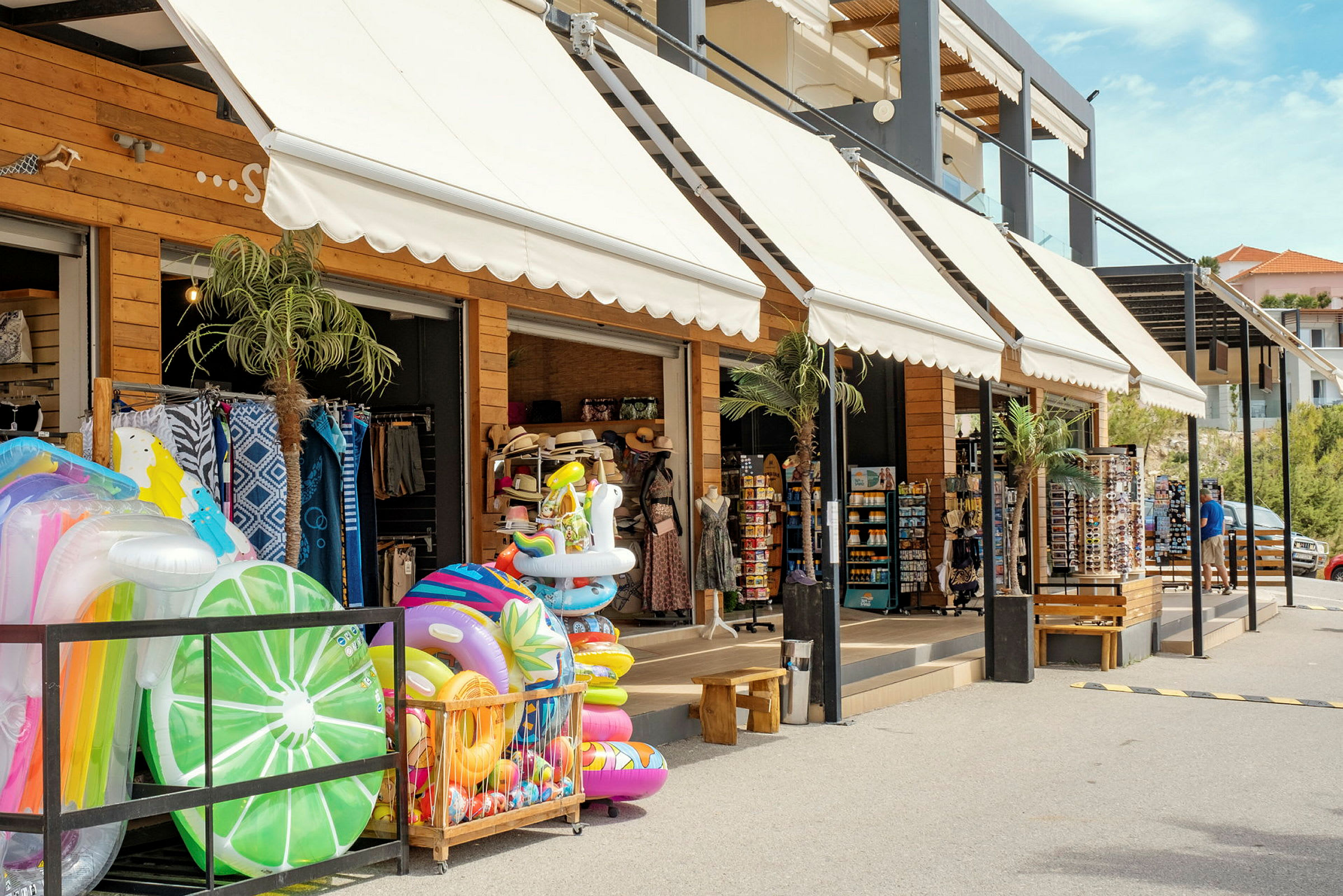 Kauppa, jossa ulkona on esillä puhallettavia uimaleluja ja lomatarvikkeita. (Tekoälyn luoma teksti)