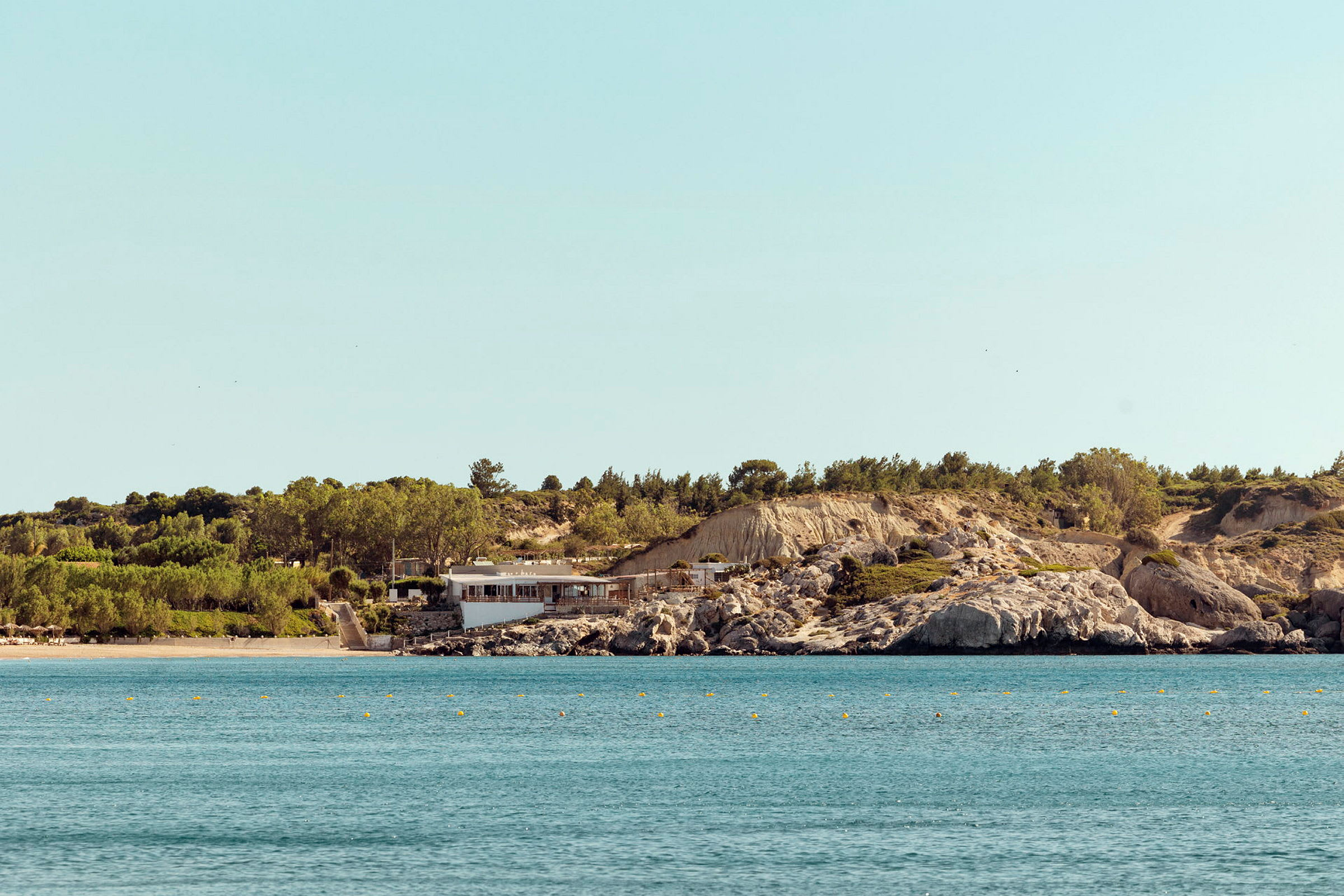 Ranta ja meri, jossa rakennus kallioisella rannikolla. (Tekoälyn luoma teksti)