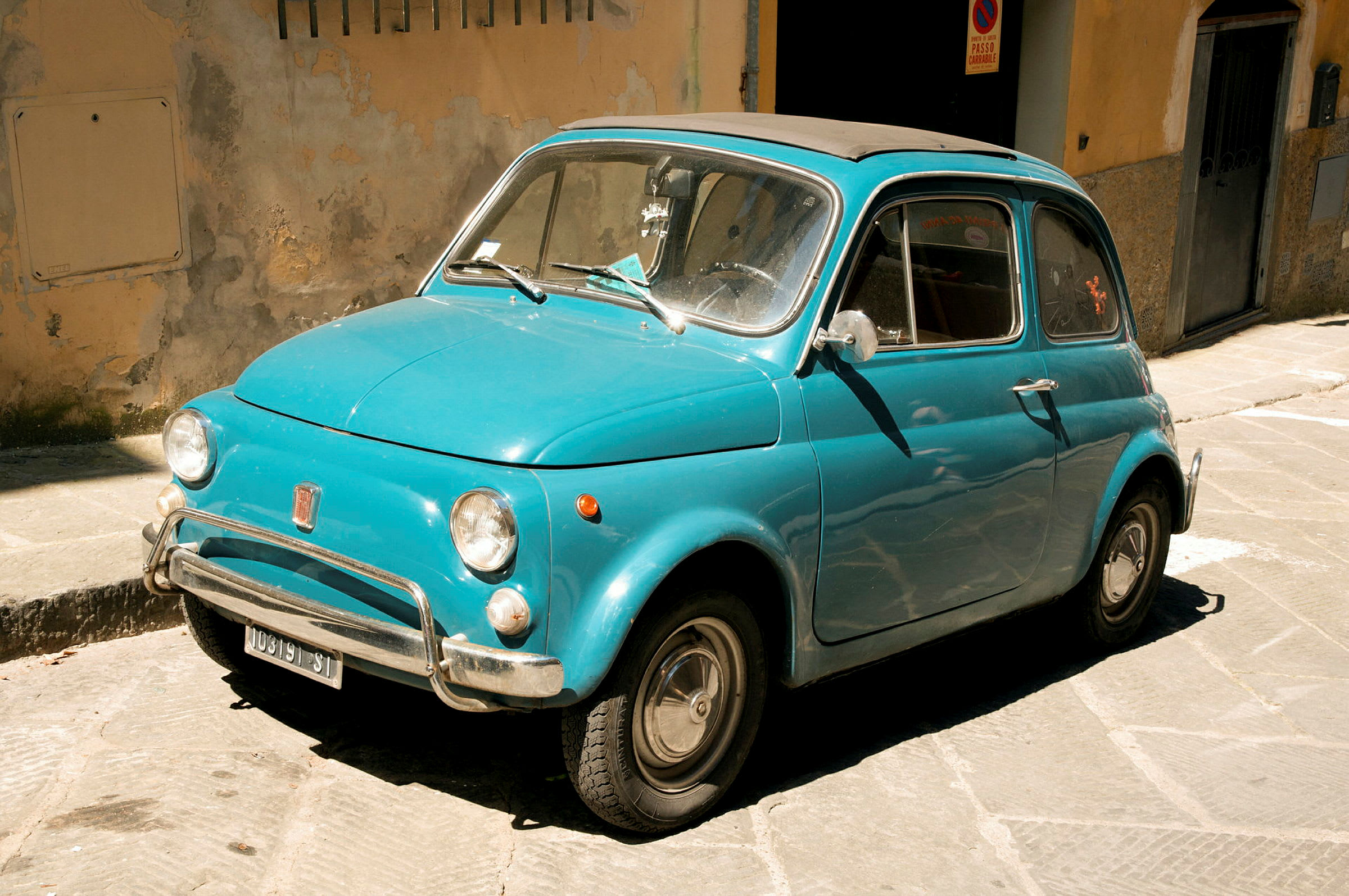 Sininen vintage-auto pysäköity lähellä seinää. (Tekoälyn luoma teksti)
