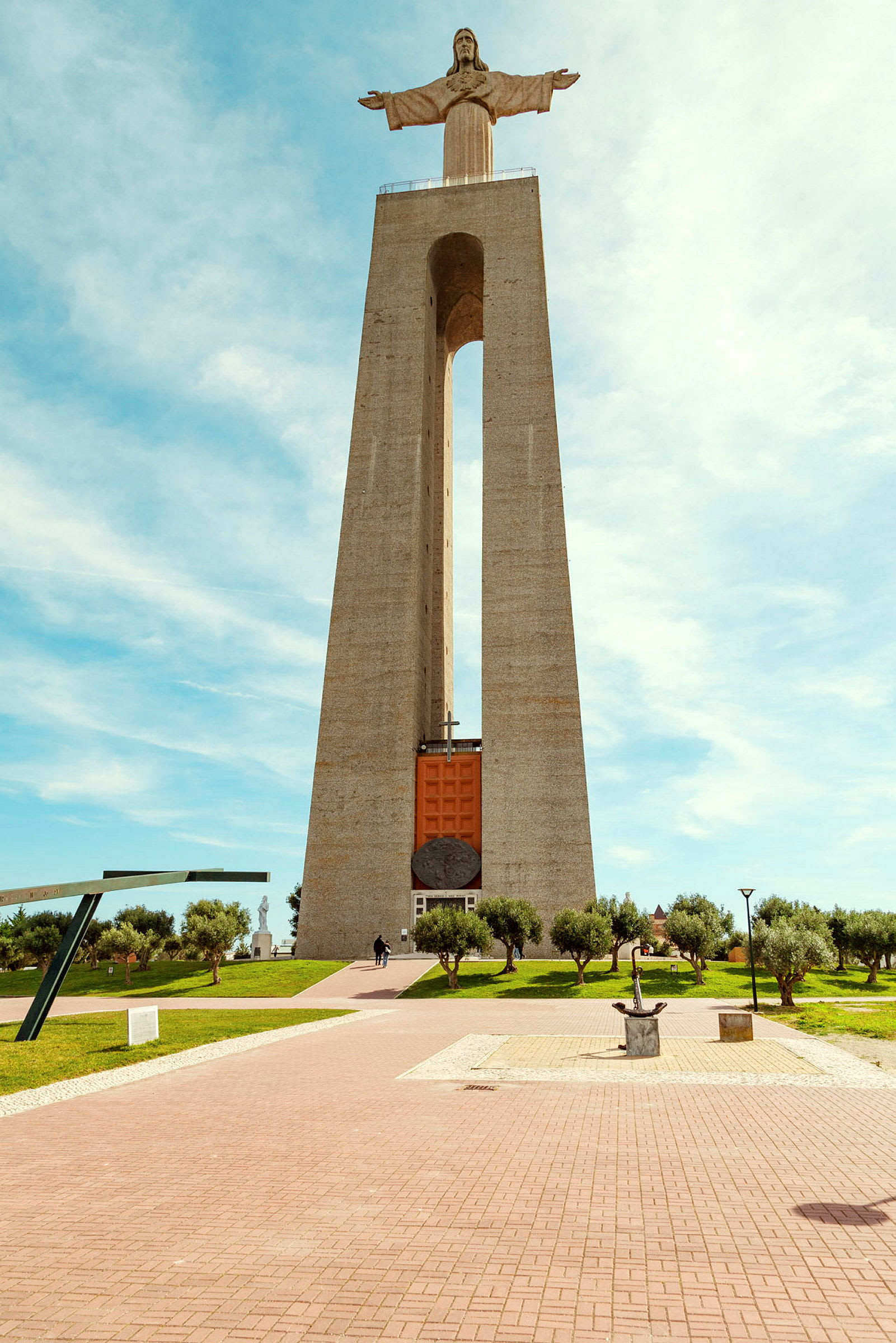Monumentti, jonka huipulla on Kristus-patsas, puiston ympäröimänä. (Tekoälyn luoma teksti)