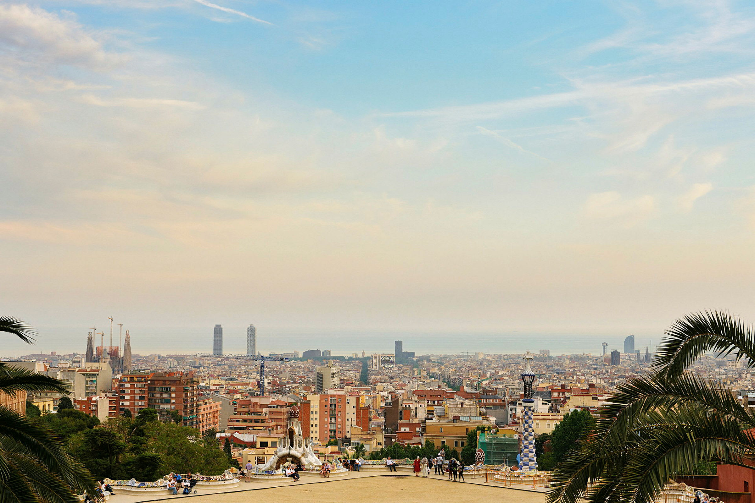 Näkymä Barcelonasta korkealta paikalta, rakennuksia, torneja ja meri kaukana. (Tekoälyn luoma teksti)