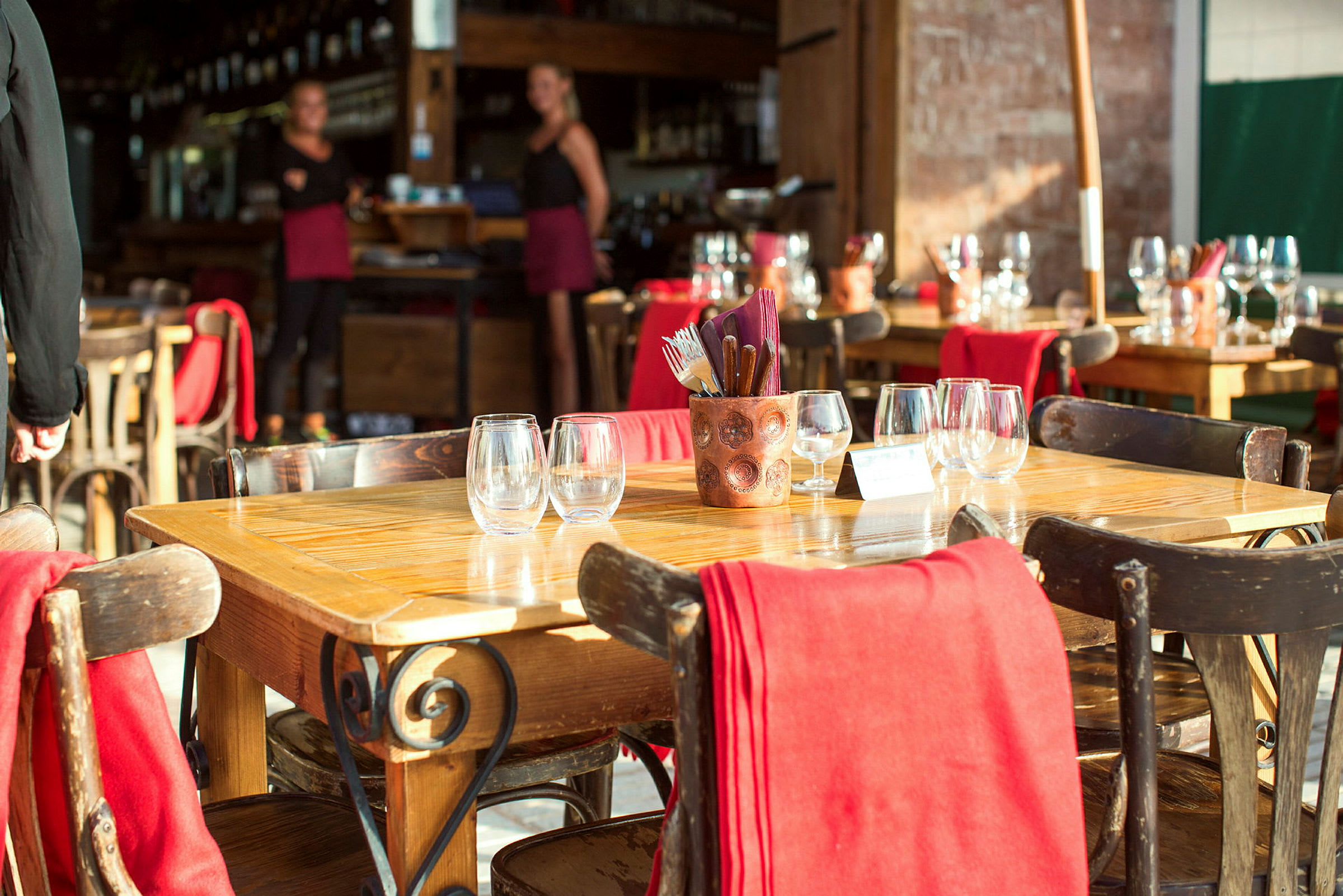Ravintola, jossa on katetut pöydät ja punaisia yksityiskohtia. (Tekoälyn luoma teksti)